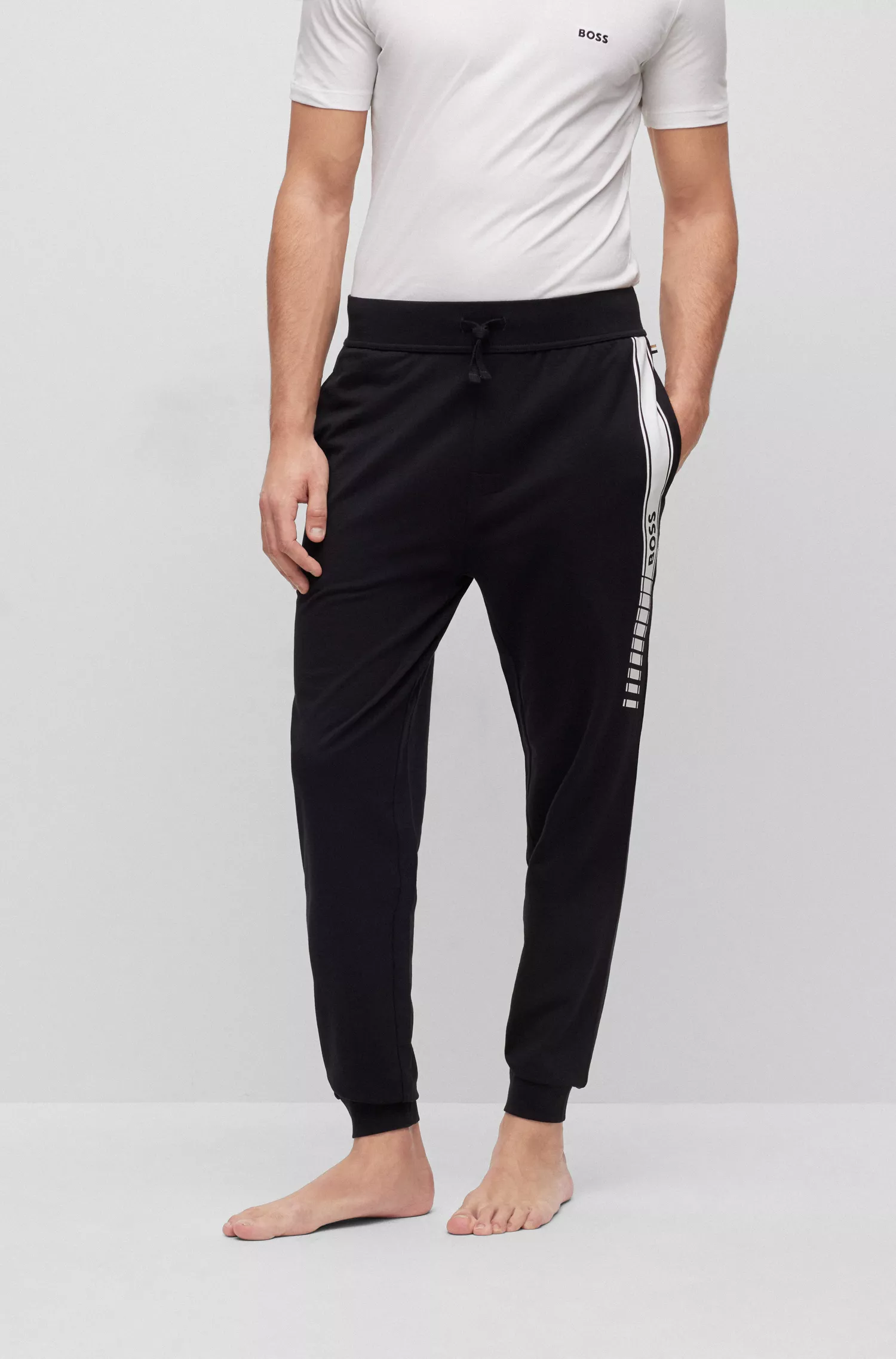 Calça de fato de treino BOSS preta em algodão orgânico com riscas e logótipo.