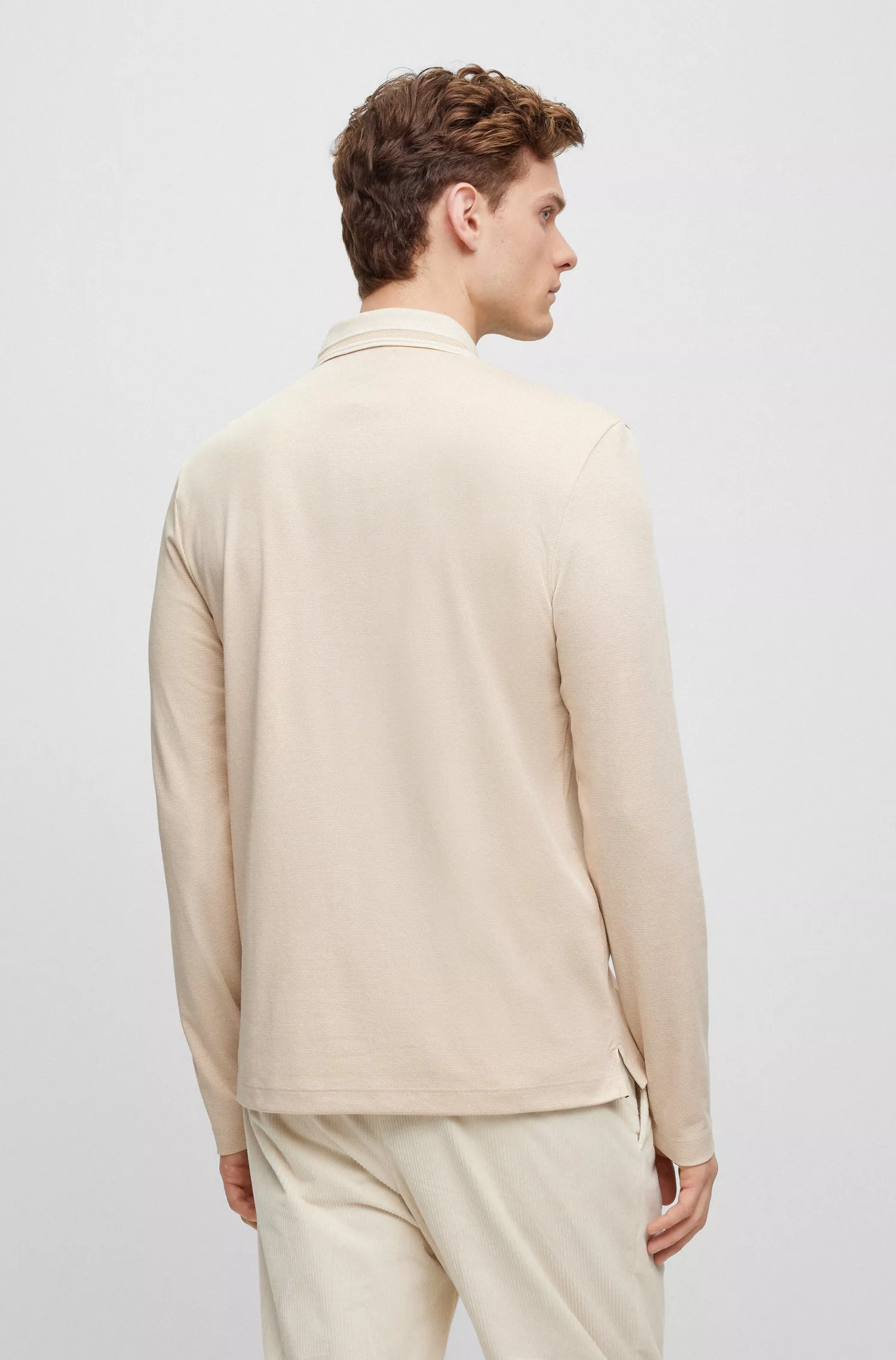 Camisa polo BOSS preta, corte slim, manga comprida e padrão trançado.