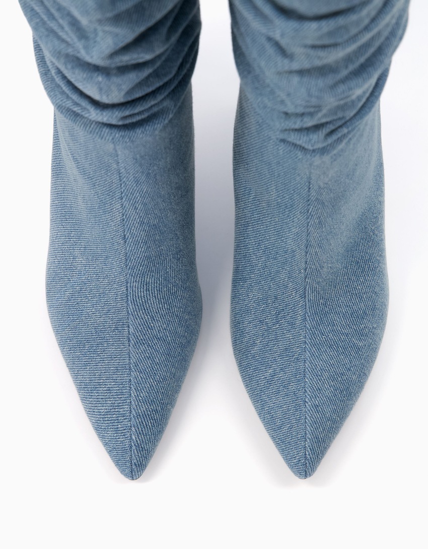 Botas de cano curto em jeans com salto baixo e modelagem folgada