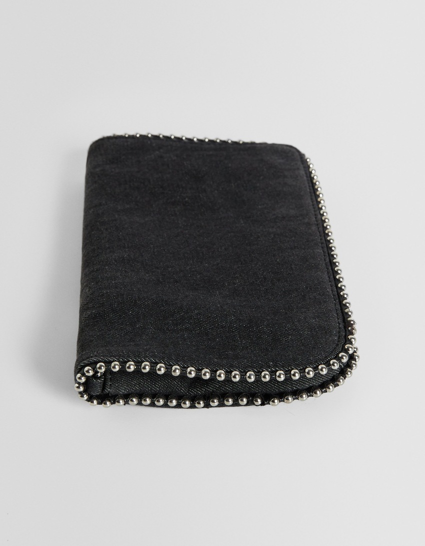 Bolsa transversal em jeans com aplicações de miçangas.