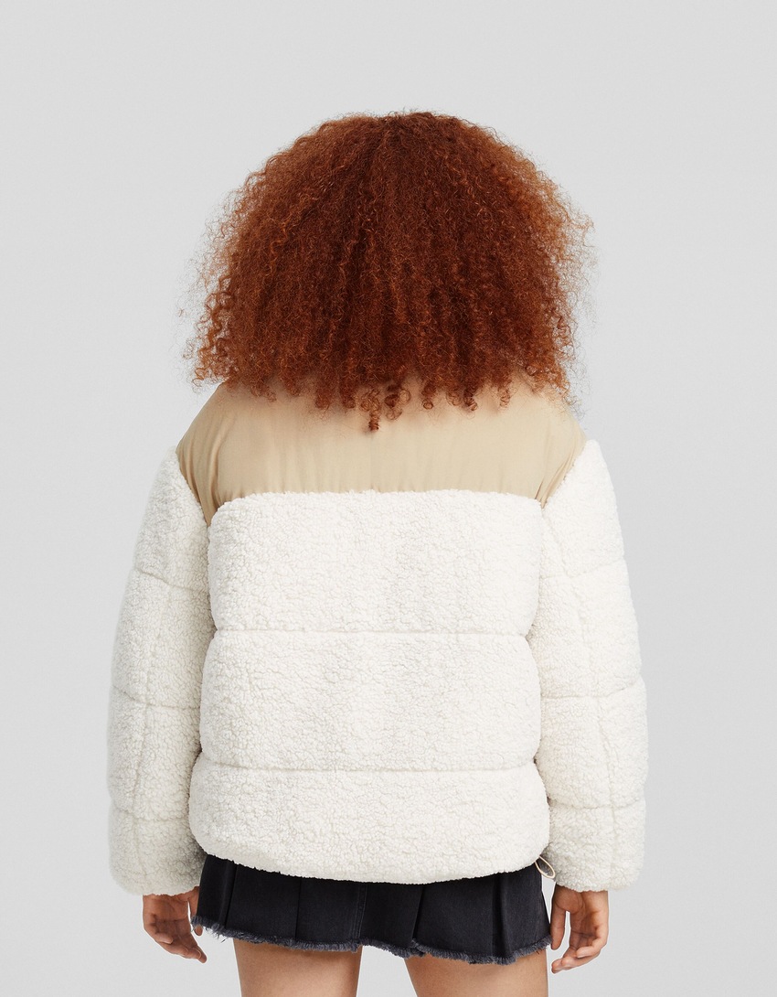 Jaqueta puffer com detalhes contrastantes em imitação de pele de carneiro e nylon.