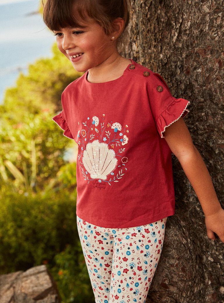 T-shirt rouge avec coquillage en sequins et petit sac fantaisie