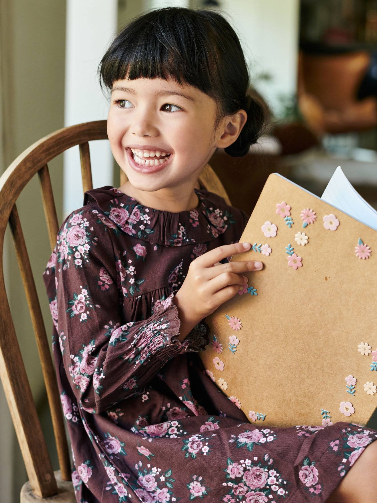 Vestido infantil com estampa floral e babados, na cor marrom escuro.