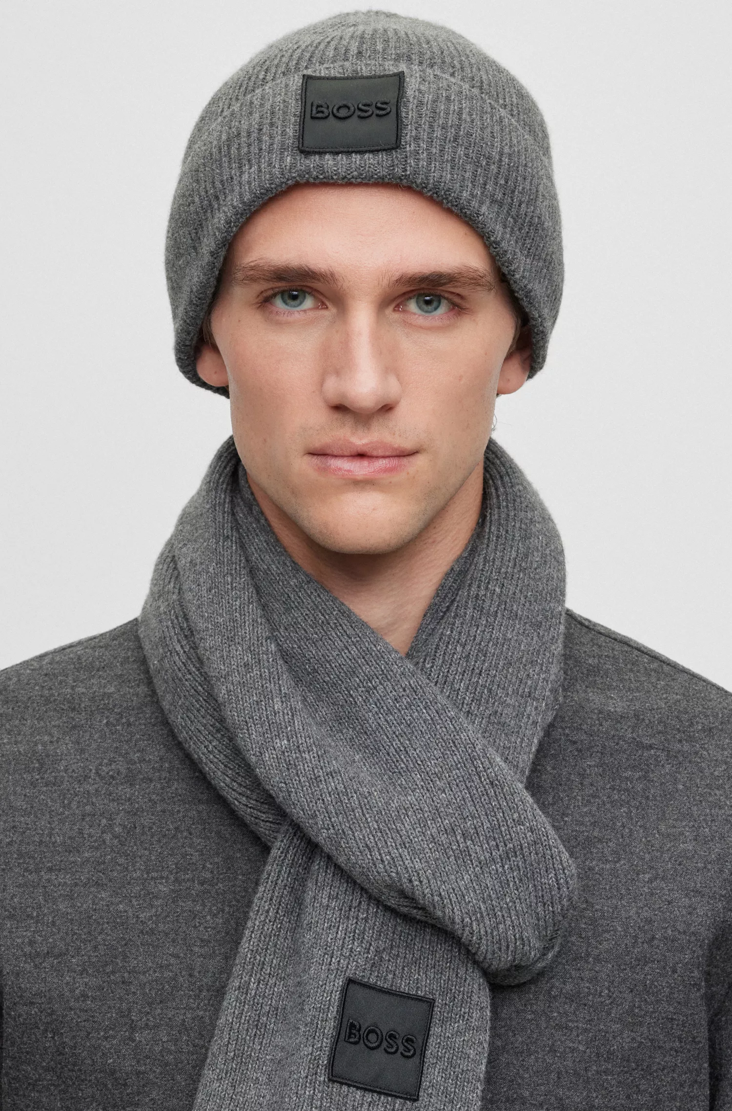 Conjunto BOSS com cachecol preto e gorro com emblema bordado.