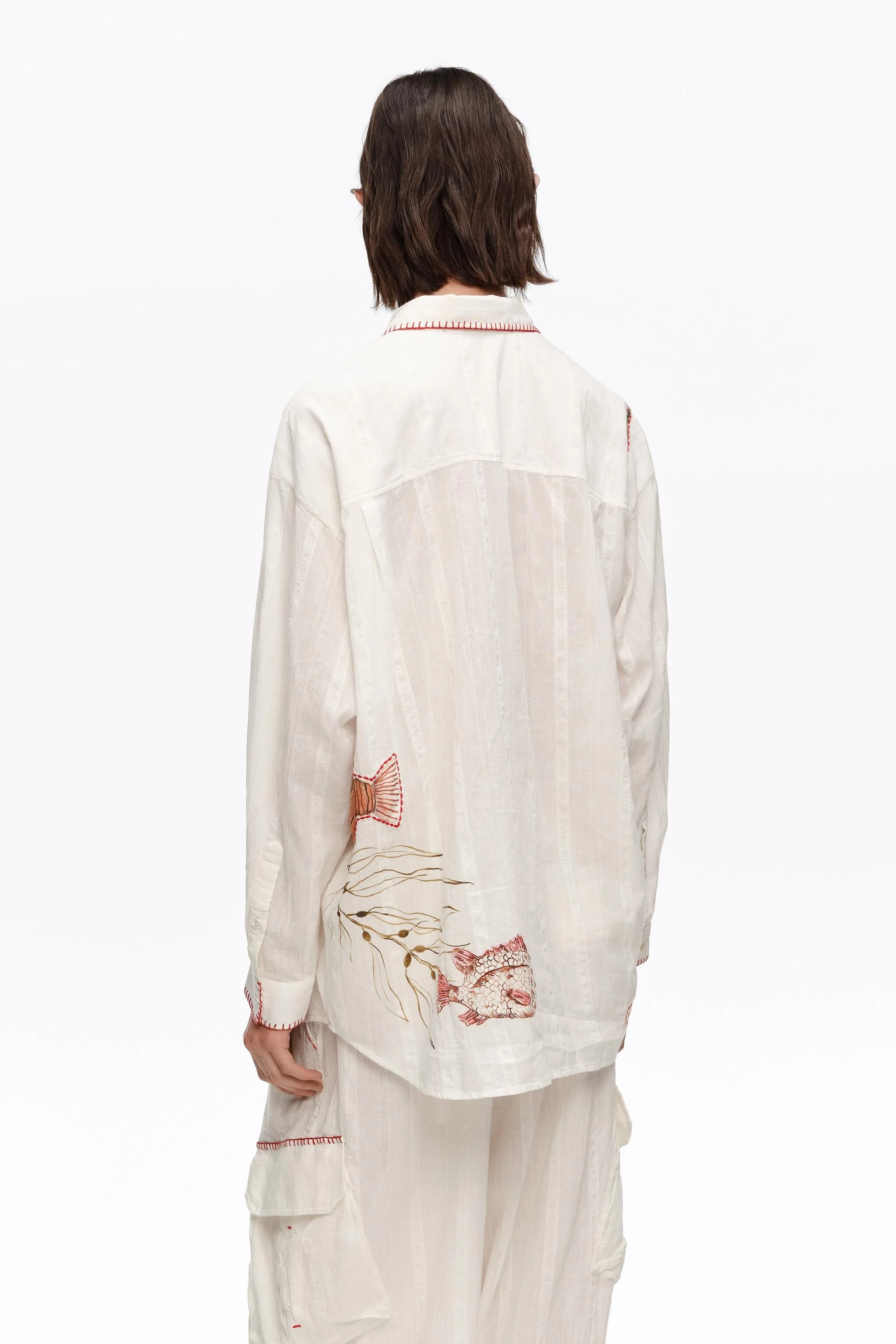 Camisa de algodão cor marfim com costuras e estampas.
