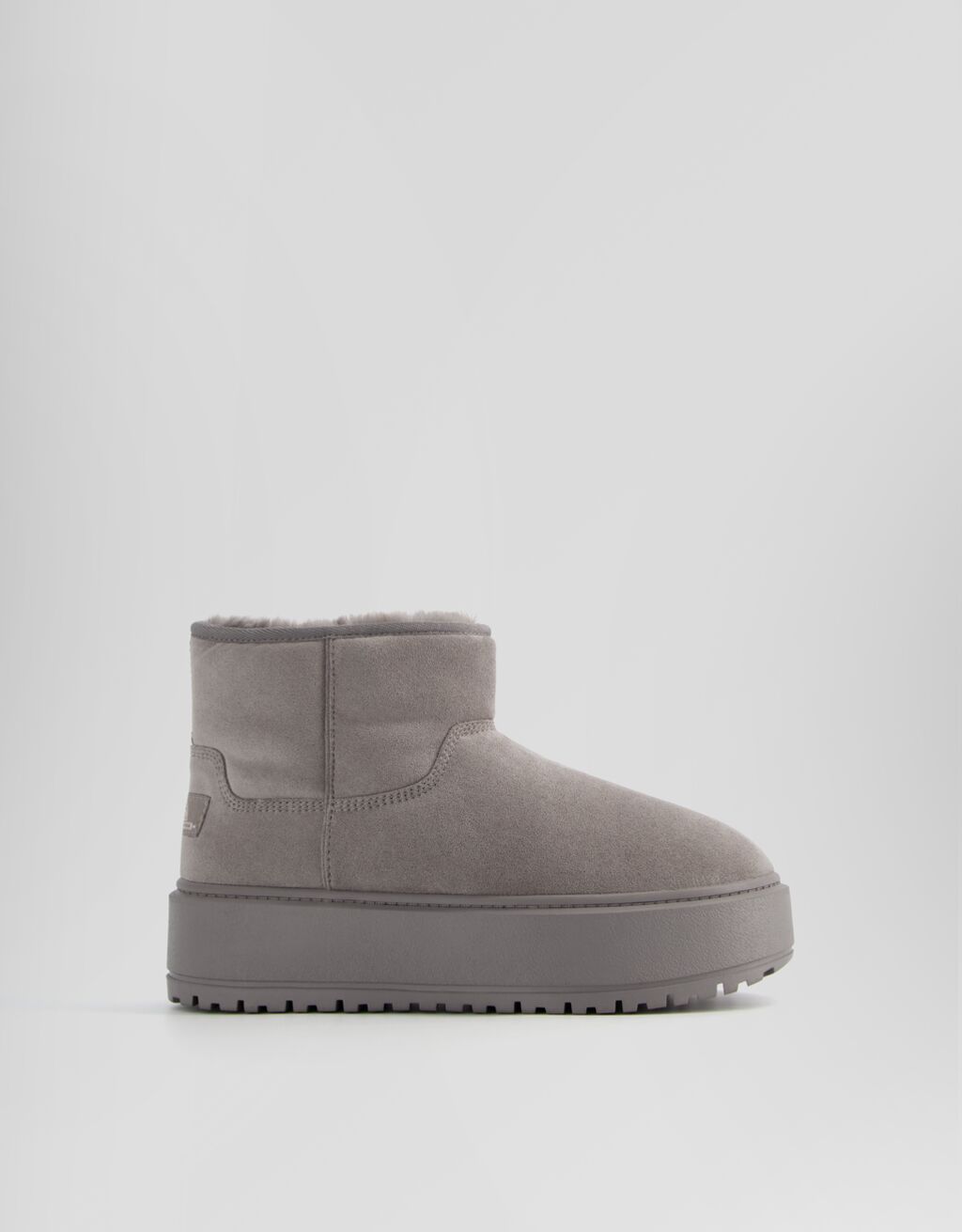 Botas de cano curto com plataforma e forro de pele sintética.
