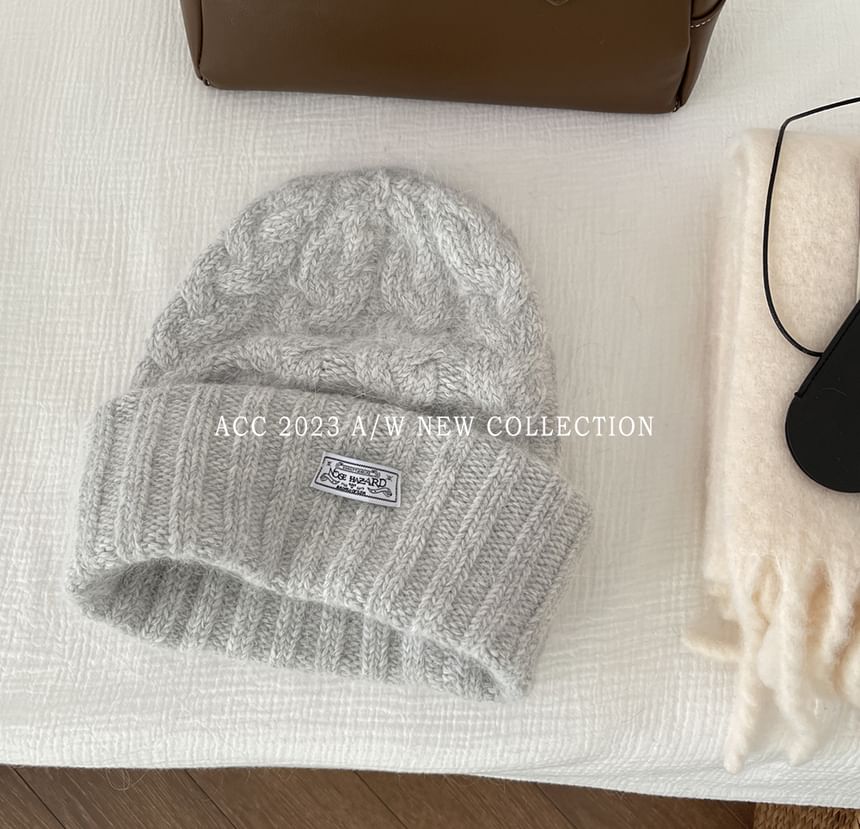 Combon - Gebreide kabelmuts met appliqué