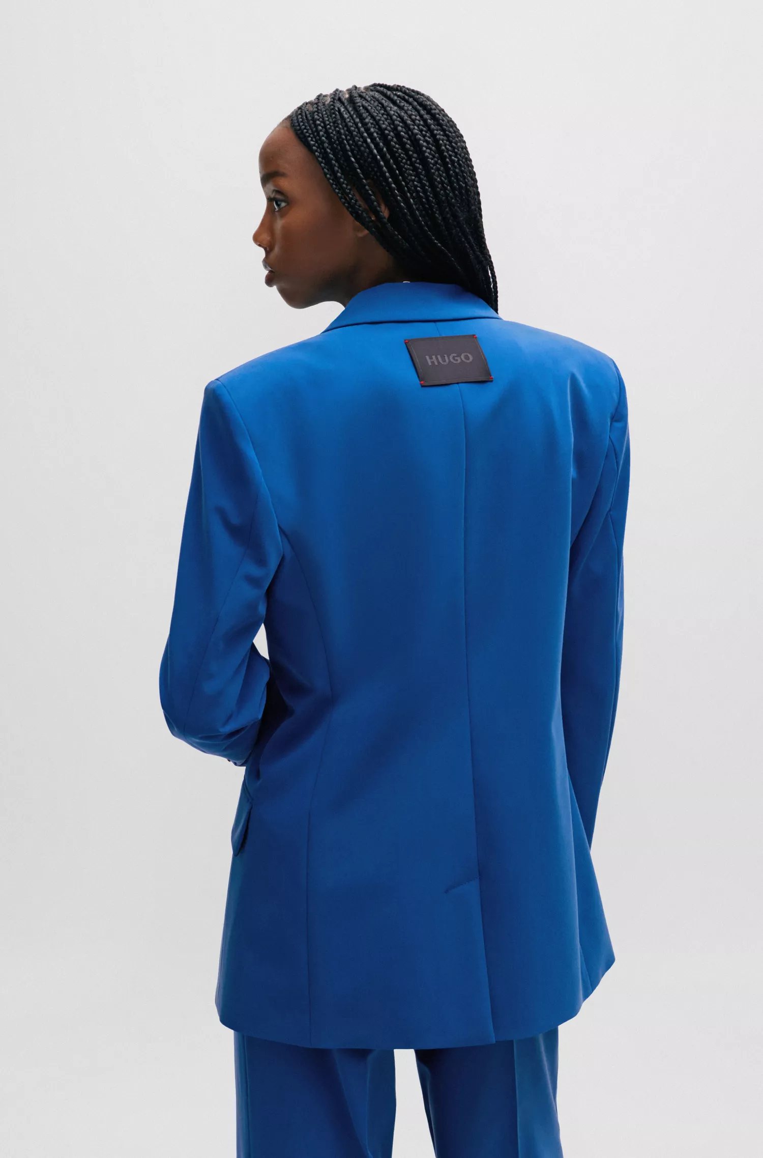 Jaqueta HUGO vermelha, modelagem relaxada e abotoamento duplo em tecido elástico.
