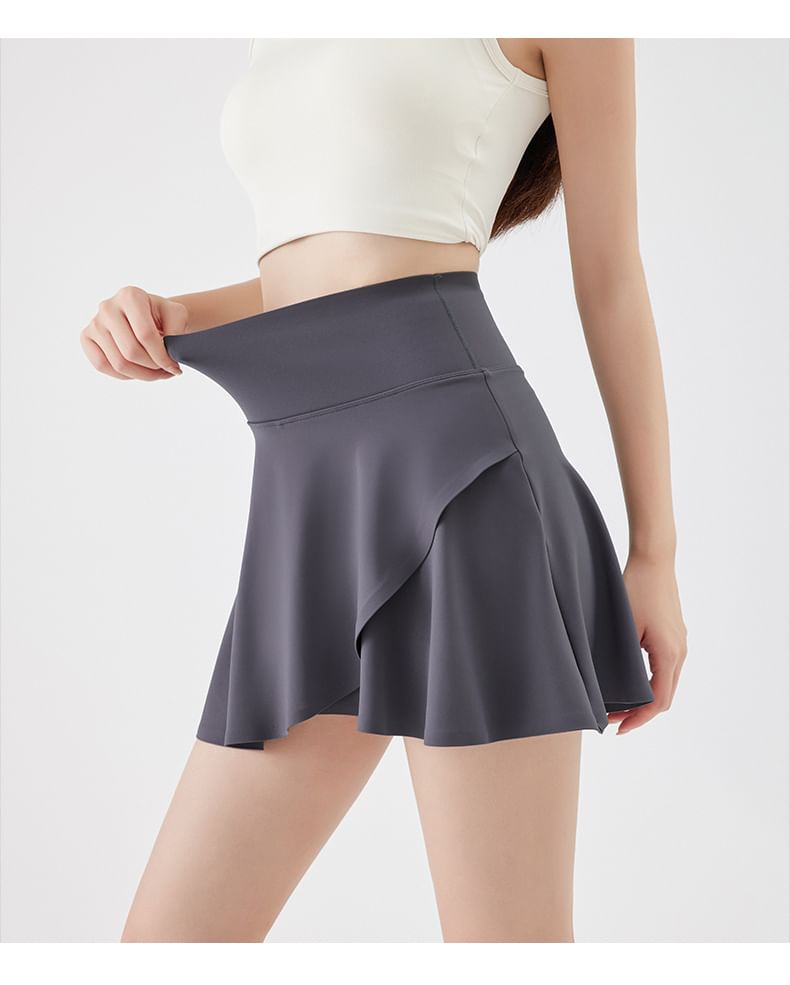 Mikiko - Asymmetrische high-rise sport-A-lijn minirok met ingezette shorts
