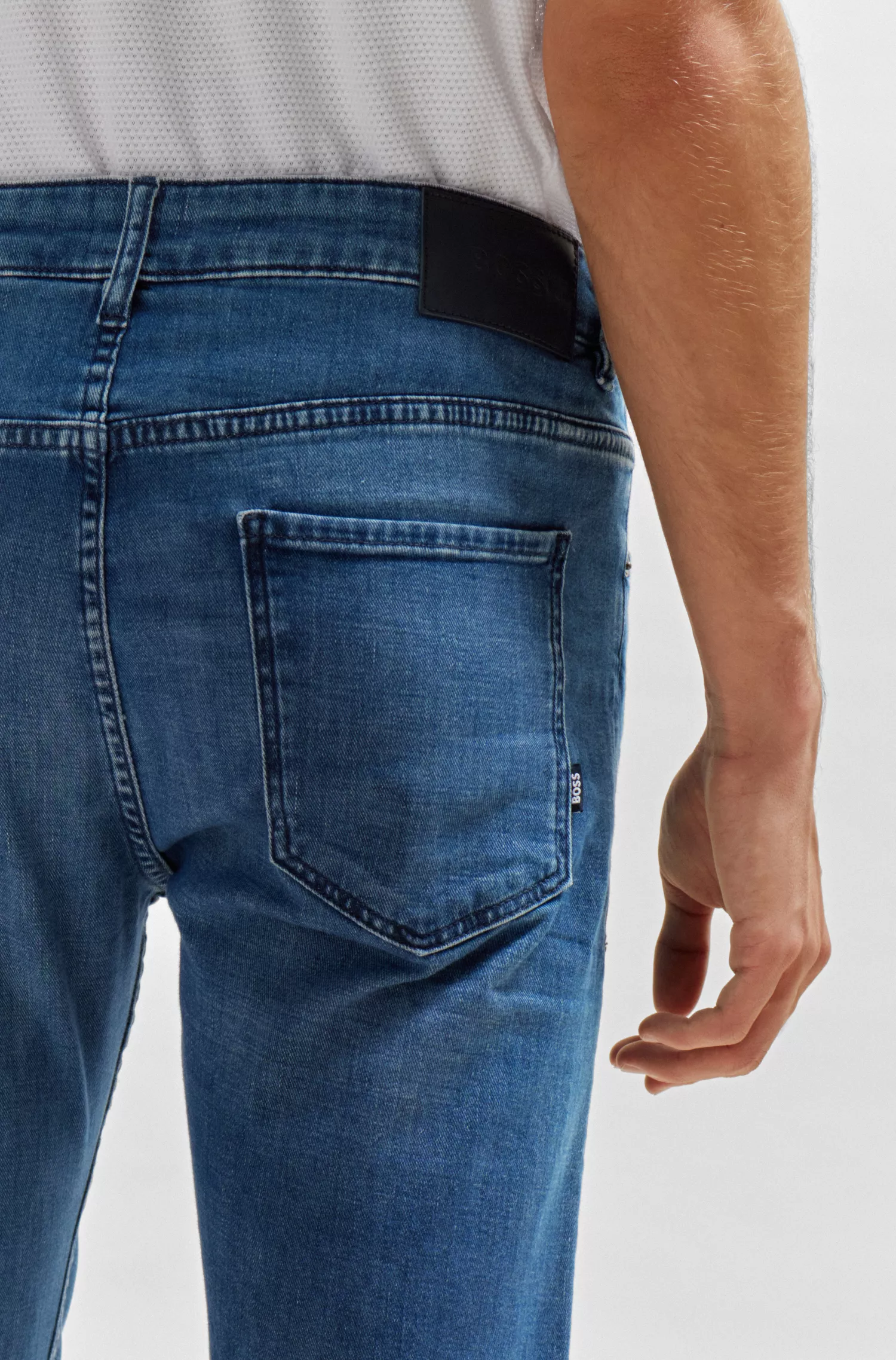 Calça jeans BOSS preta, corte afunilado, em denim elástico azul.