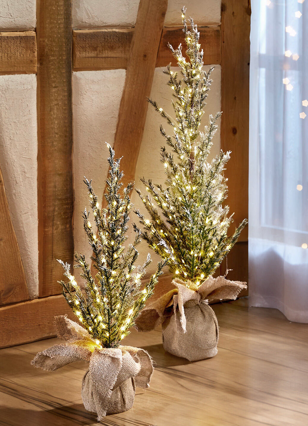 Beleuchteter Tannenbaum in Jutesäckchen