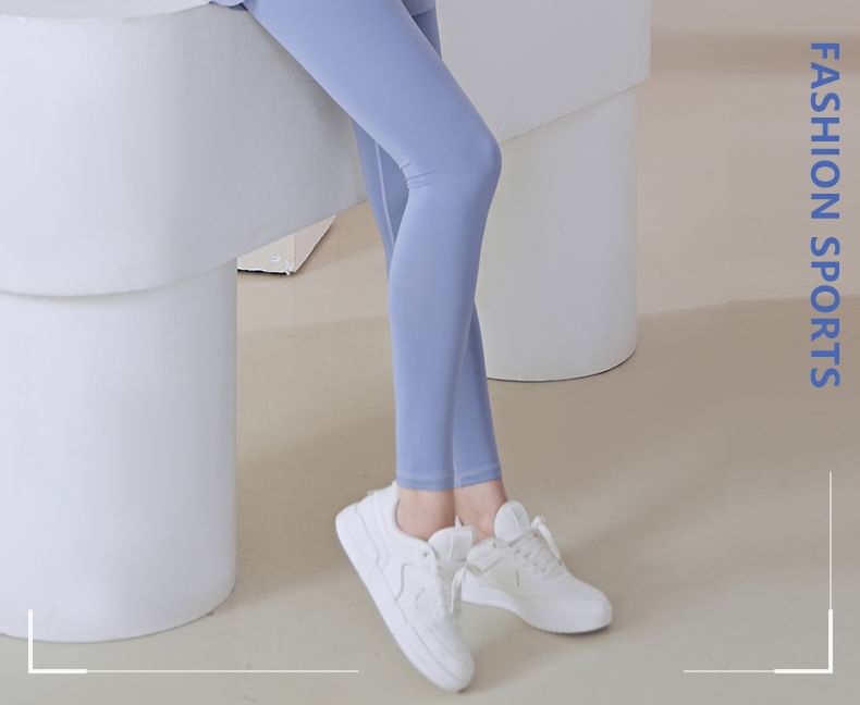 FAYE - Set: sport-T-shirt met korte mouwen, inkeping in de hals en ruches + tweedelige yogalegging met hoge taille