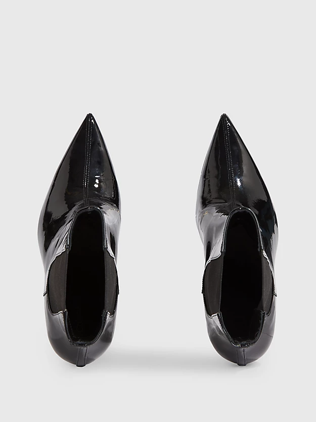 Botas de cano curto em verniz com salto agulha.