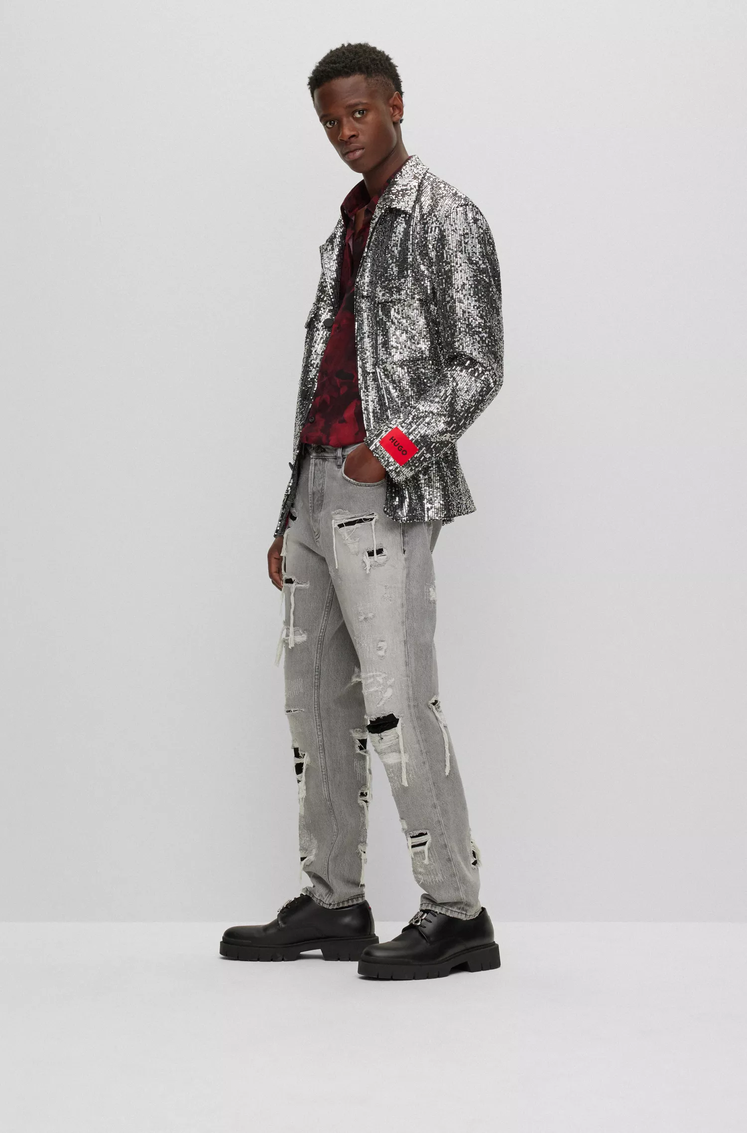 Calça jeans HUGO vermelha, corte afunilado, em denim cinza-prateado com efeito desgastado.