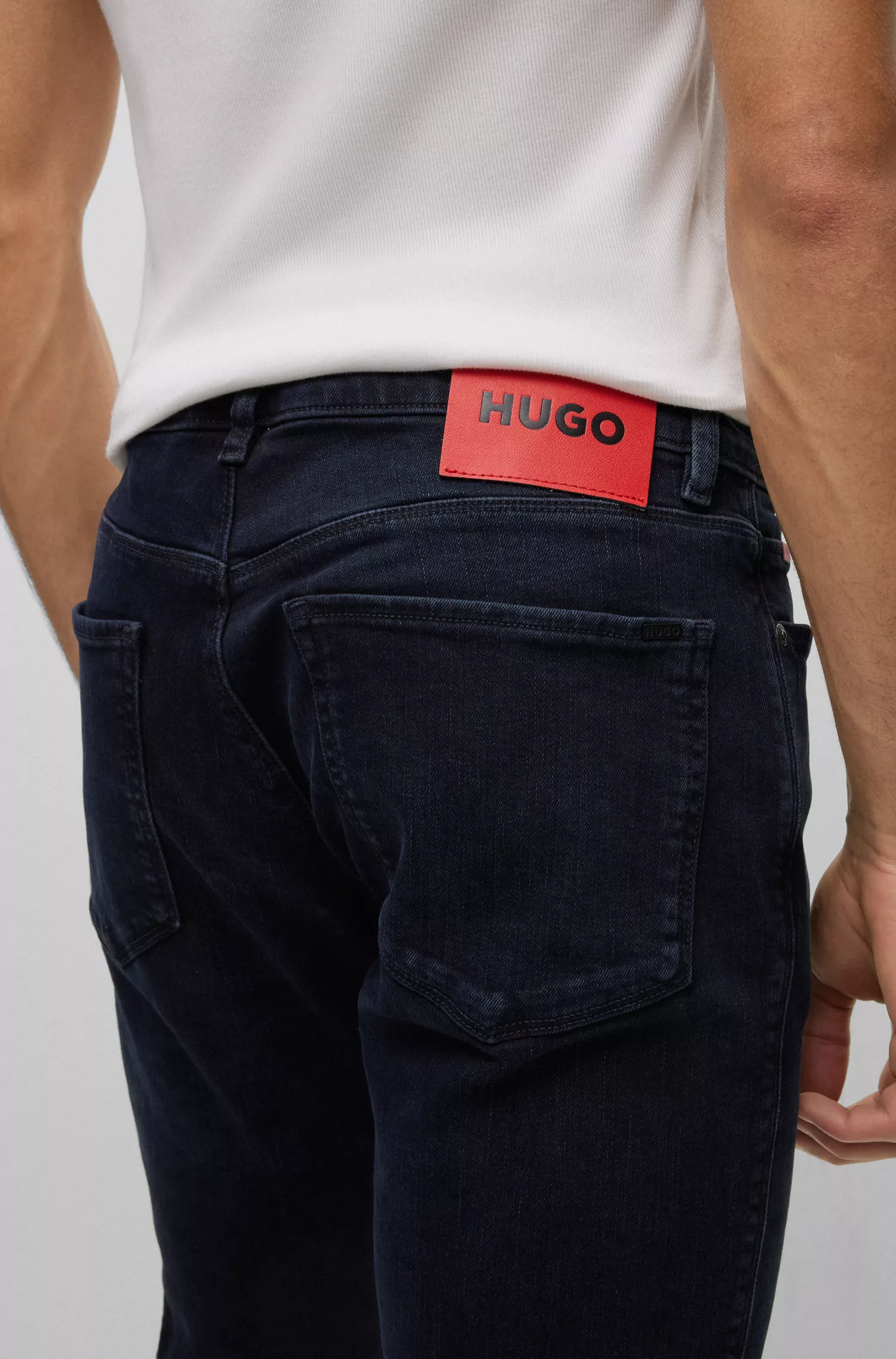 Calça jeans HUGO vermelha, extra slim fit, em denim stretch azul-preto.
