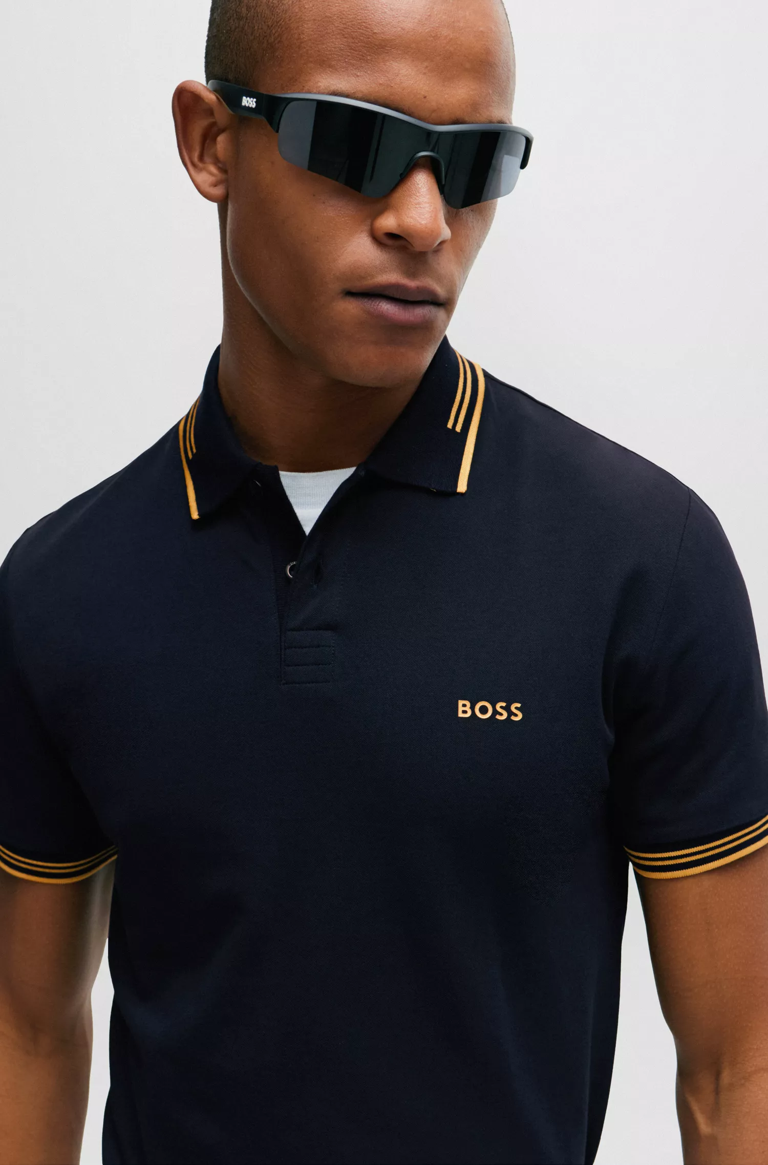 Camisa polo BOSS verde, de algodão stretch, corte slim, com a marca estampada.
