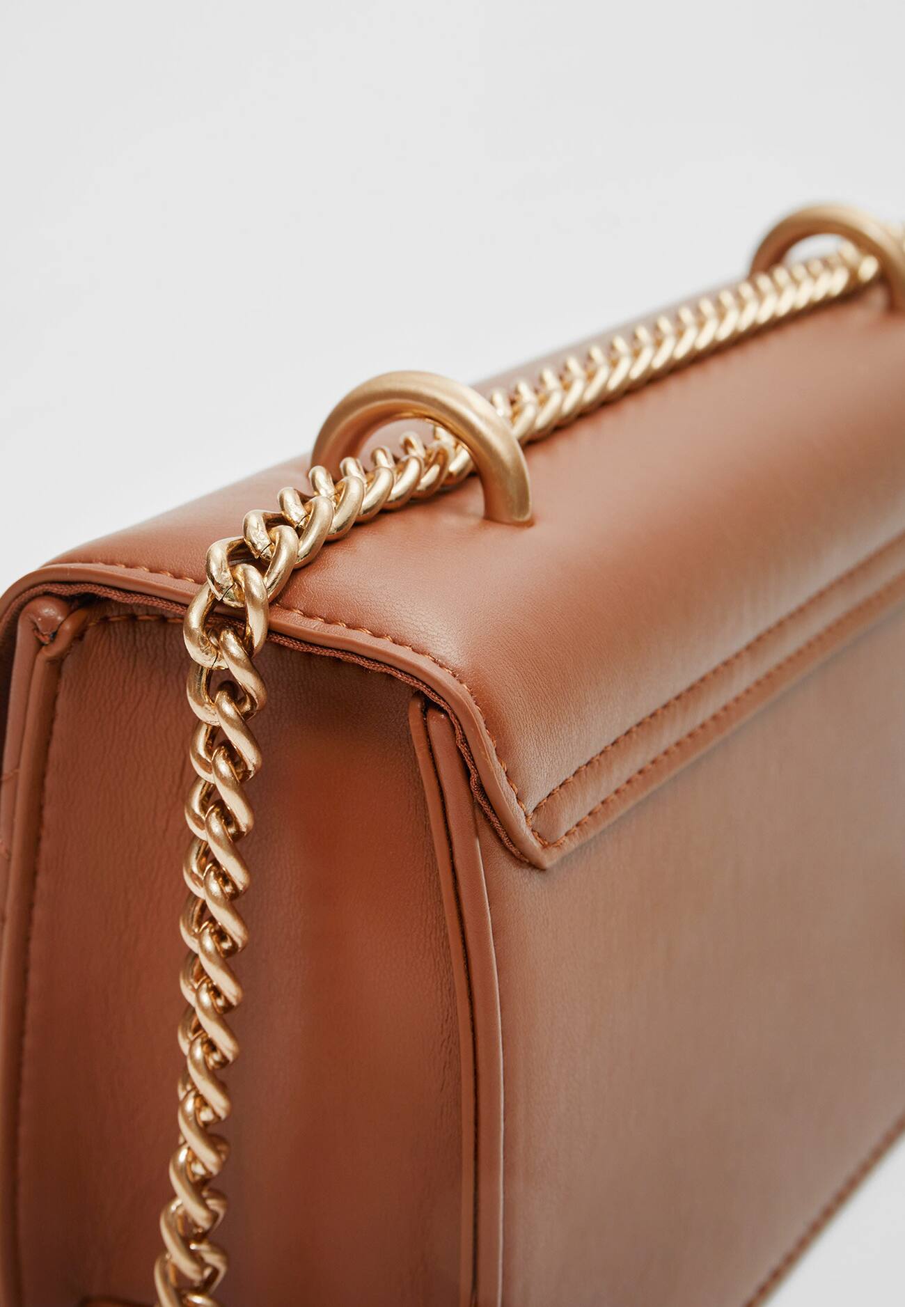 Bolsa transversal com aba e fecho.