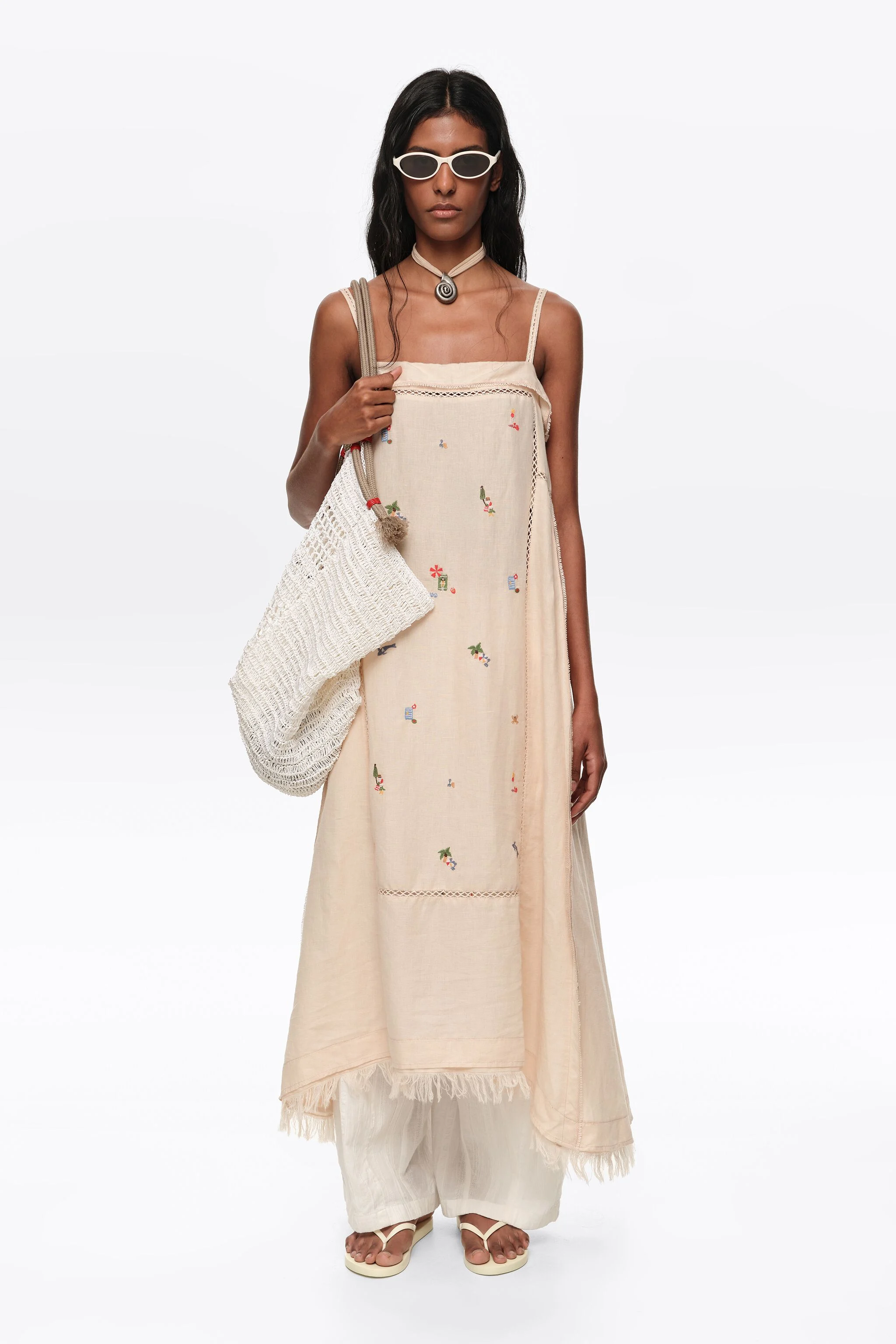 Vestido curto evasê em linho cor areia com bordado.
