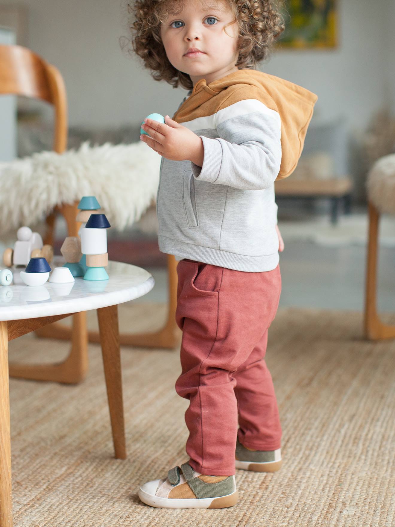 Jaqueta infantil masculina marrom-clara lisa com zíper, capuz e detalhes decorativos.