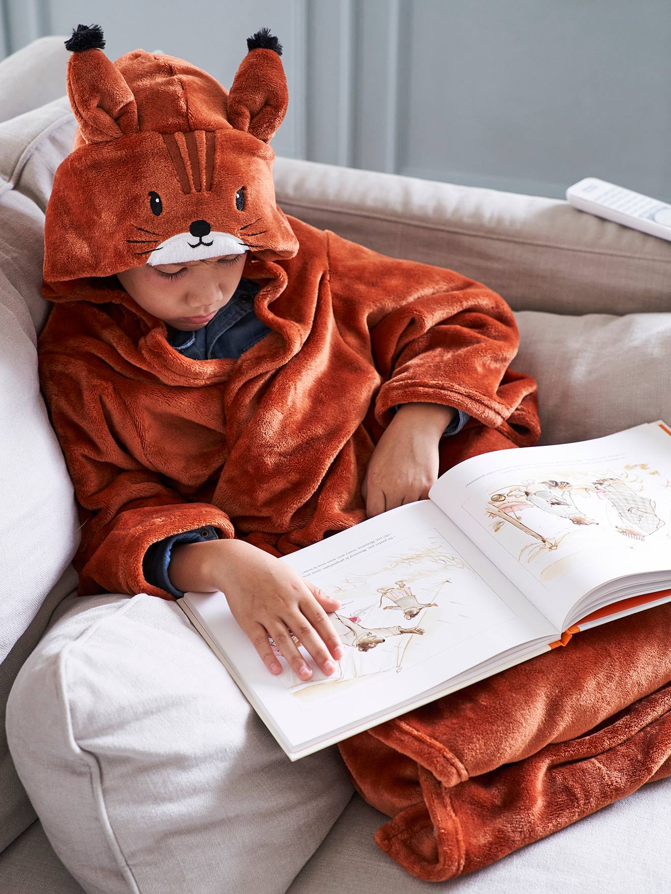 Manta com estampa animal e mangas, lisa em tom médio de roxo com motivos.