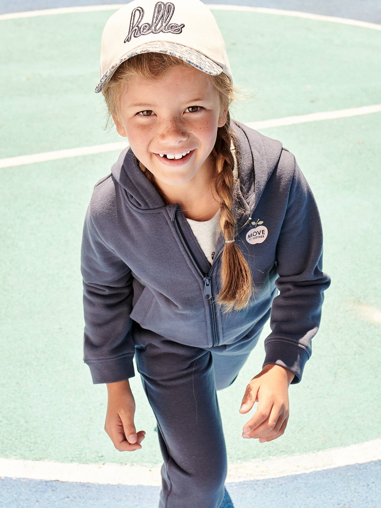 Moletom infantil feminino azul médio liso com zíper, capuz esportivo e detalhes decorativos.