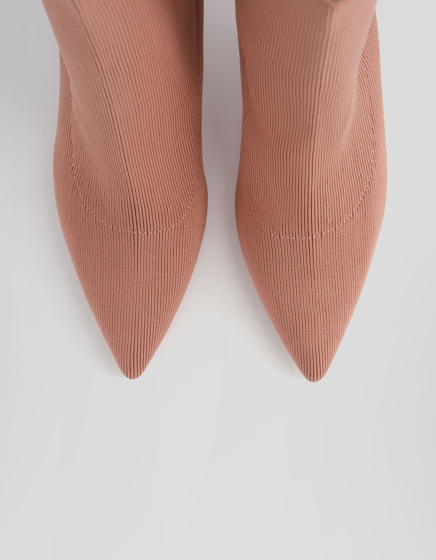 Botas de cano curto com salto alto e modelagem ajustada