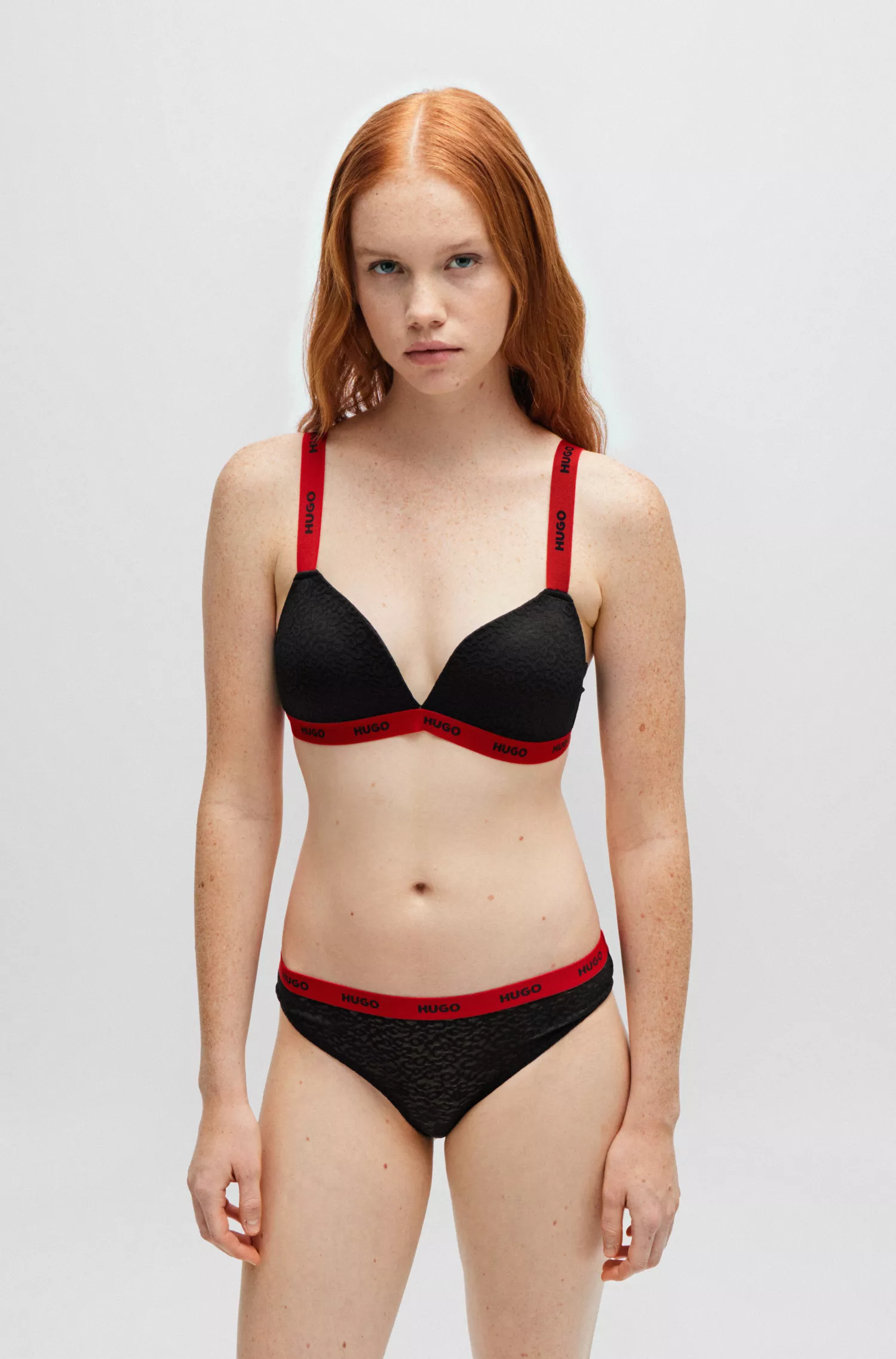 Sutiã triangular HUGO em renda vermelha com detalhes contrastantes da marca.