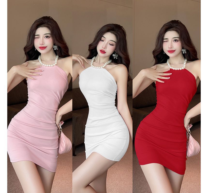 Aurora - Mini bodyconjurk met halterhals en imitatieparels