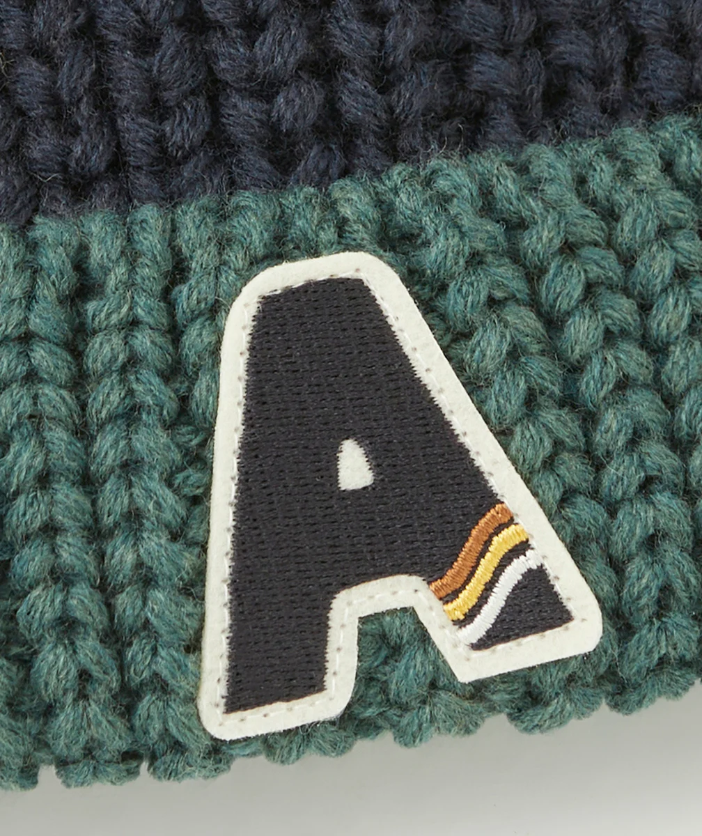 BONNET EN TRICOT GARÇON EN FIBRES RECYCLÉES BLEU ET VERT AVEC POMPON OCRE