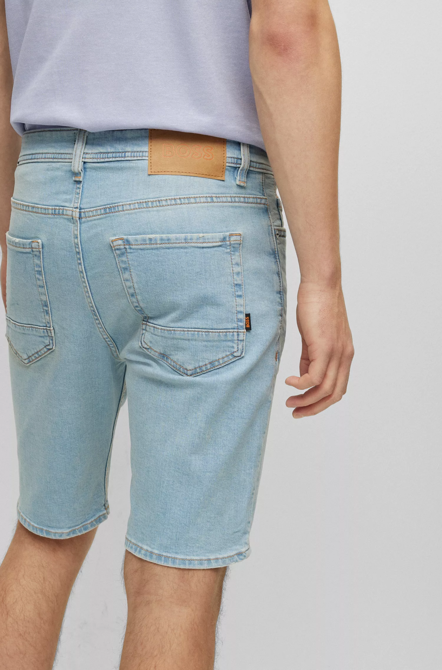 Shorts BOSS laranja com modelagem afunilada em jeans elástico para maior conforto.