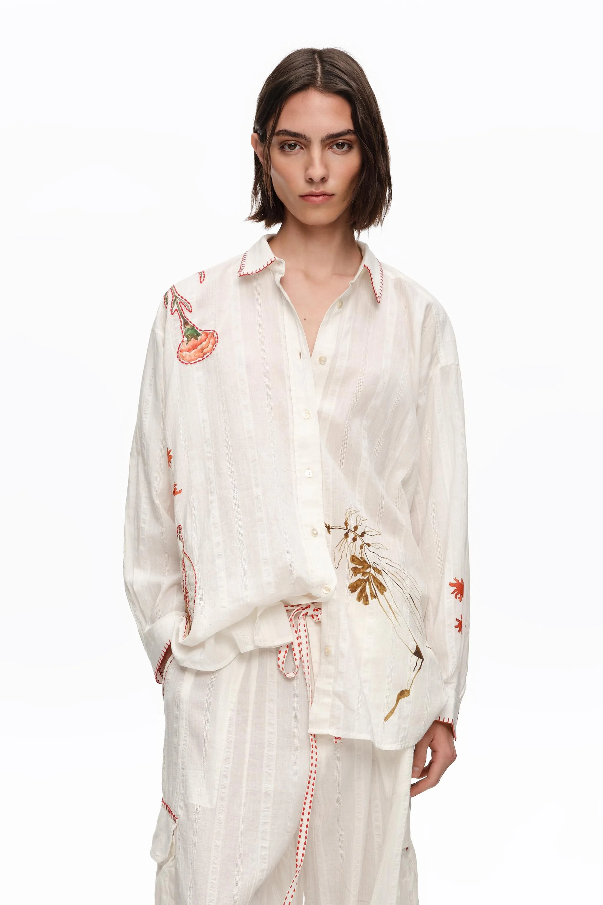 Camisa de algodão cor marfim com costuras e estampas.