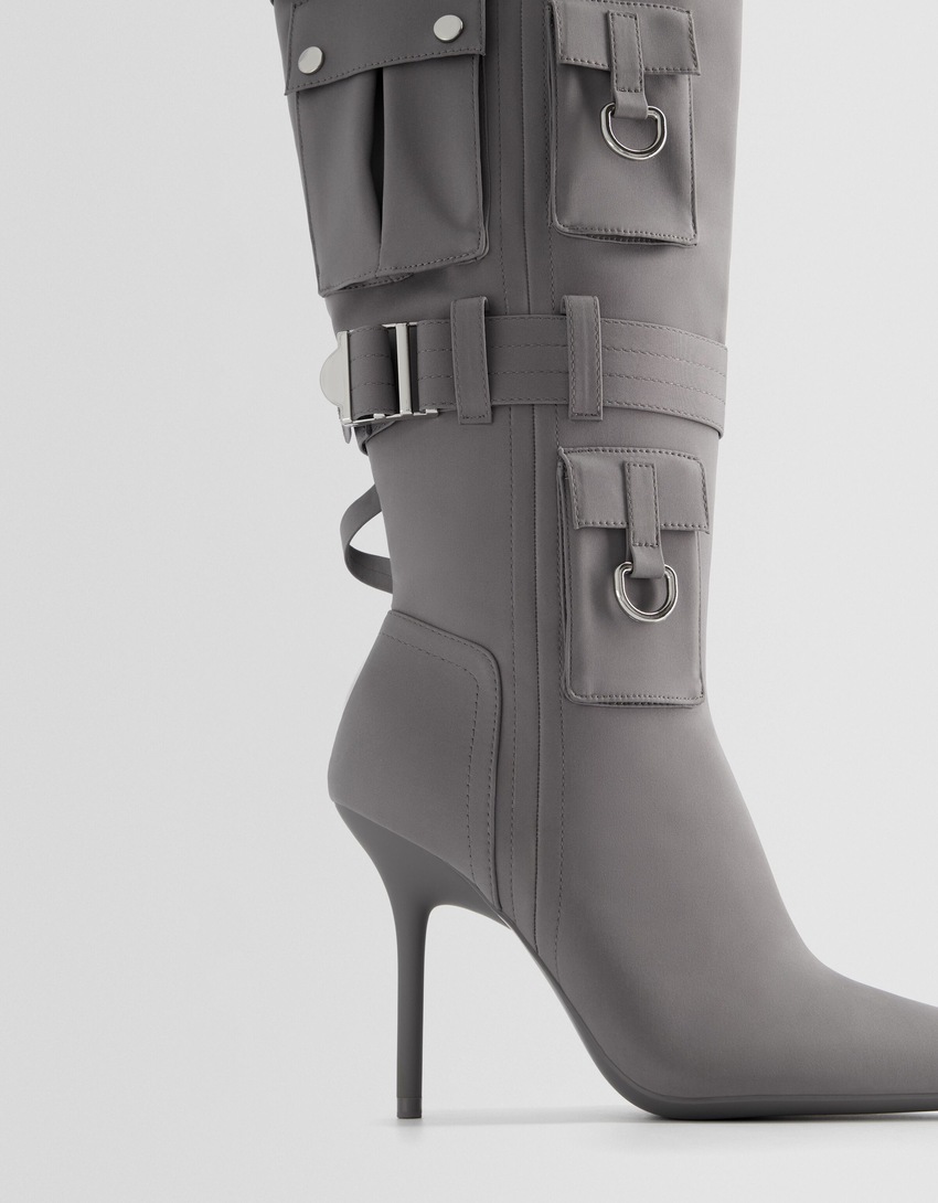 Botas de salto agulha com bolsos com detalhes em metal.