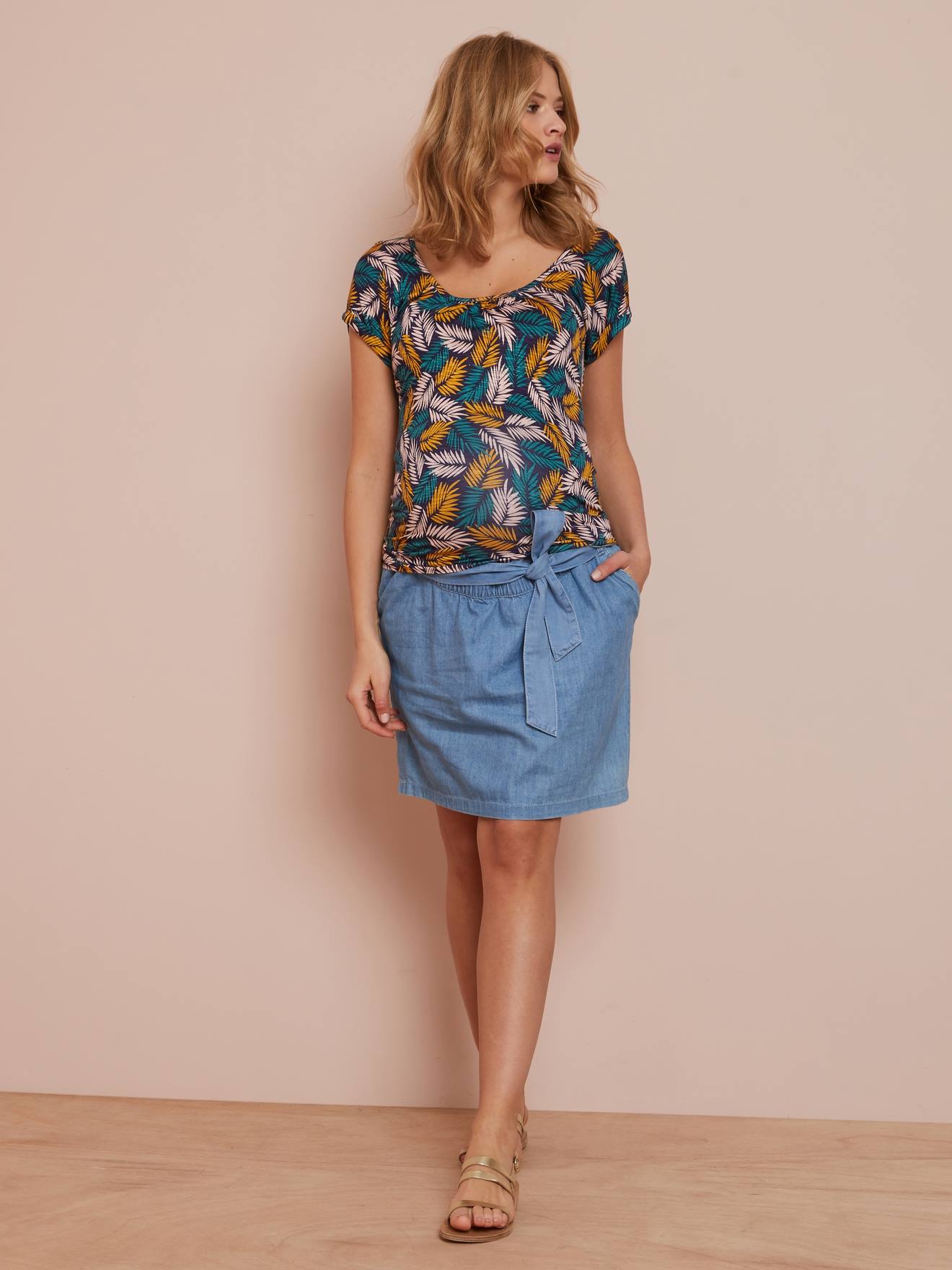 Saia jeans para gestantes com cinto azul de lavagem média.