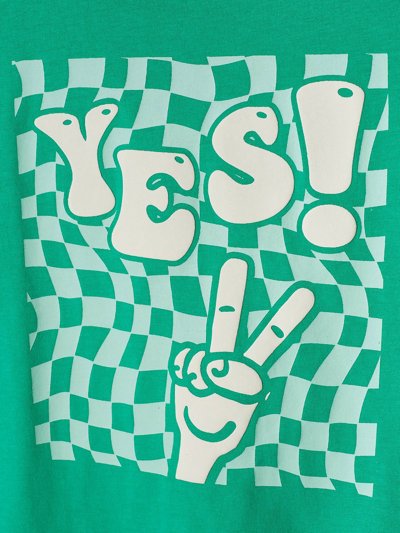 Camiseta verde infantil com estampa gigante e detalhes em relevo.