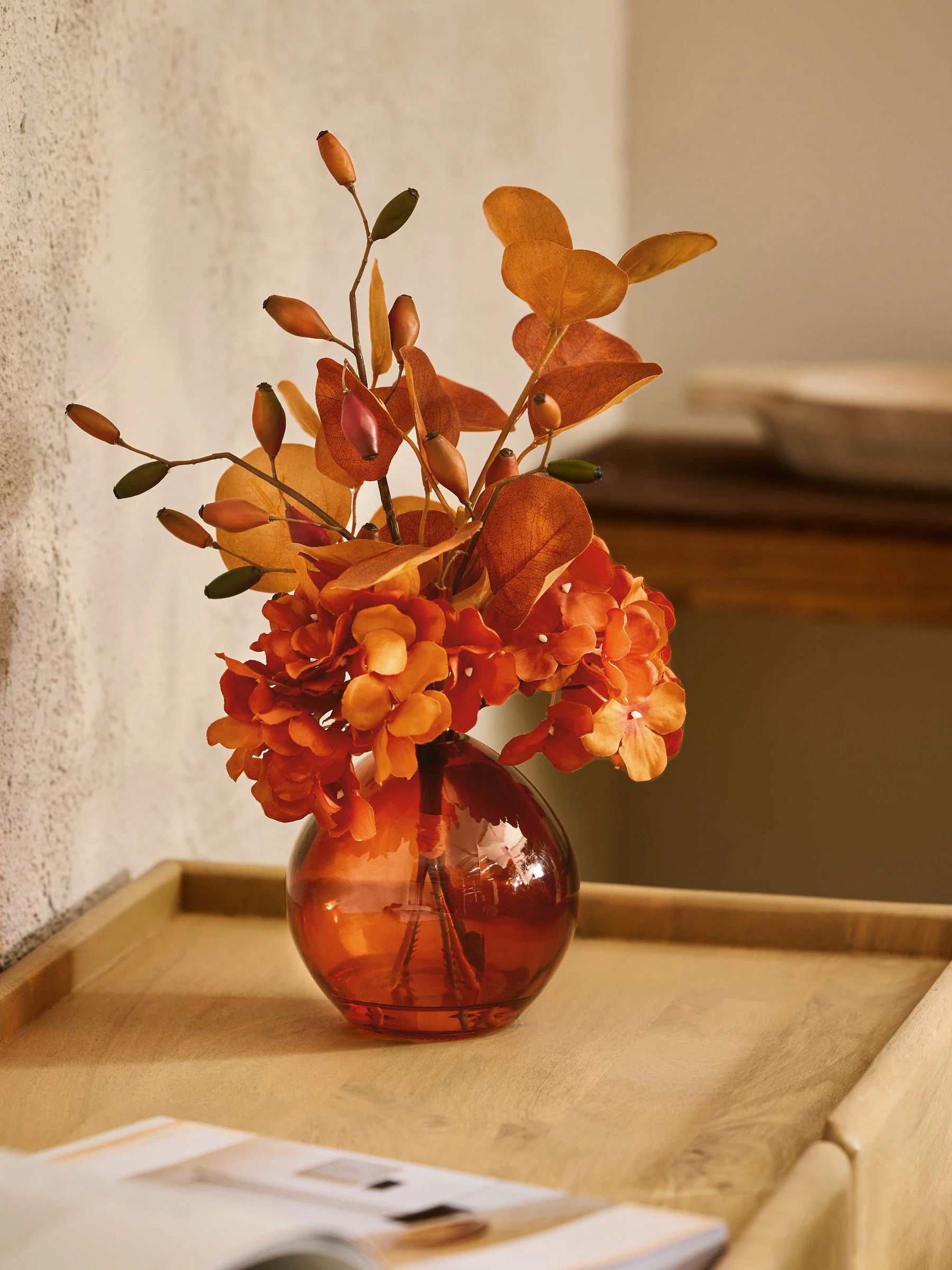 Arrangement met kunsthortensia in glazen vaas