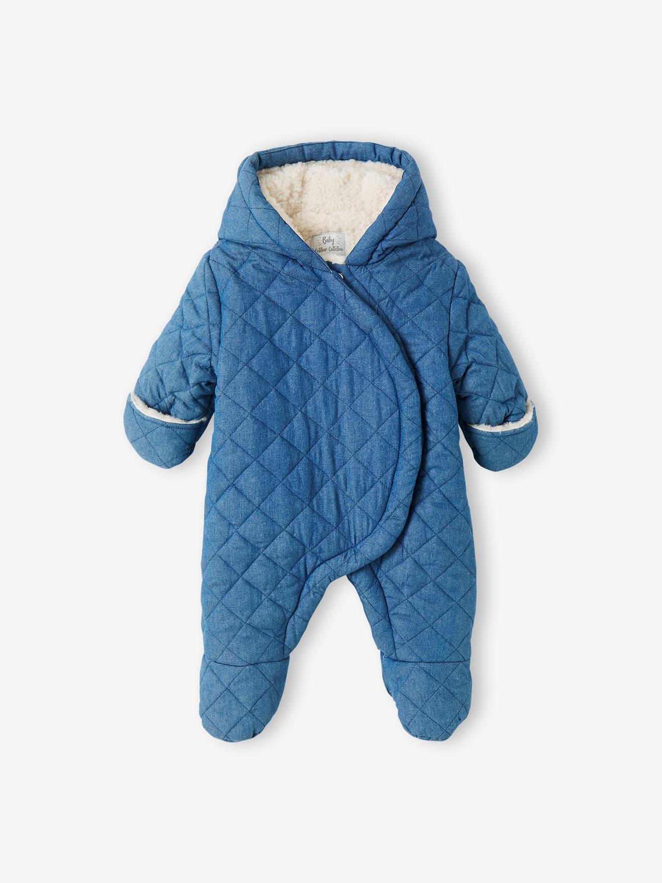 Macacão jeans chambray azul médio para bebê menina, estilo piloto, com abertura assimétrica.
