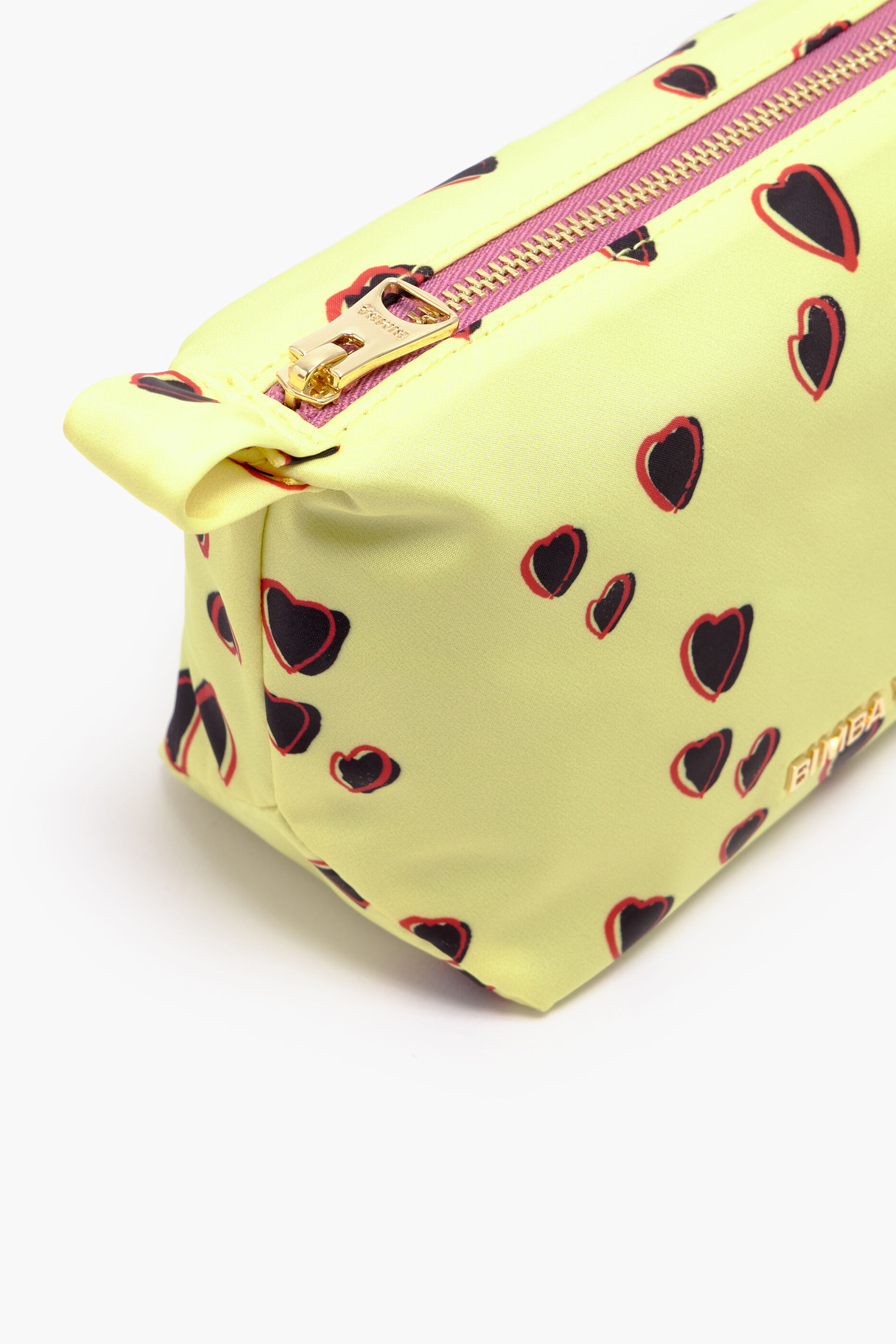 Nécessaire trapezoidal com estampa de corações pequenos em amarelo.