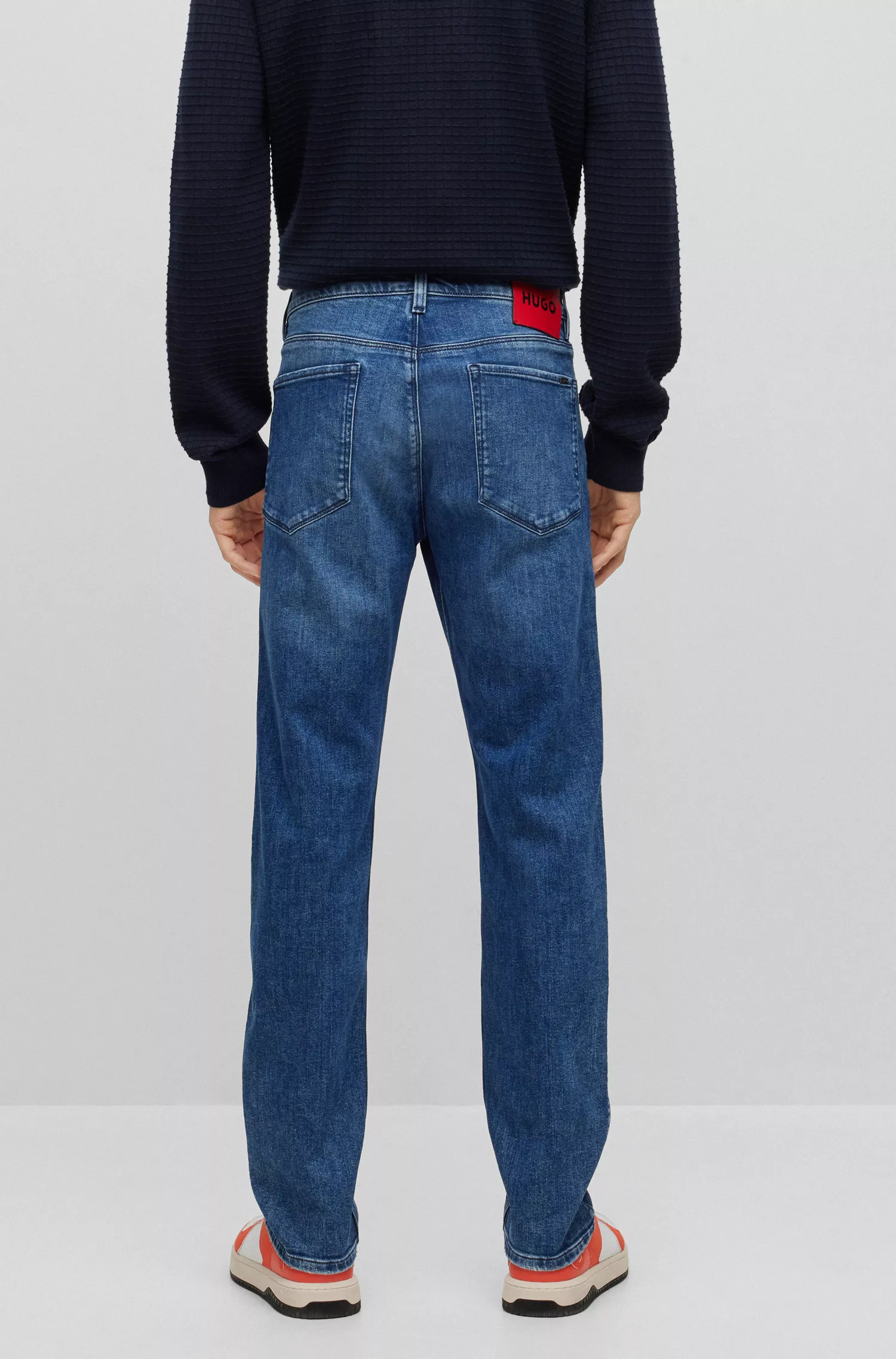 Calça jeans HUGO vermelha, corte slim, em denim azul com elasticidade para maior conforto.