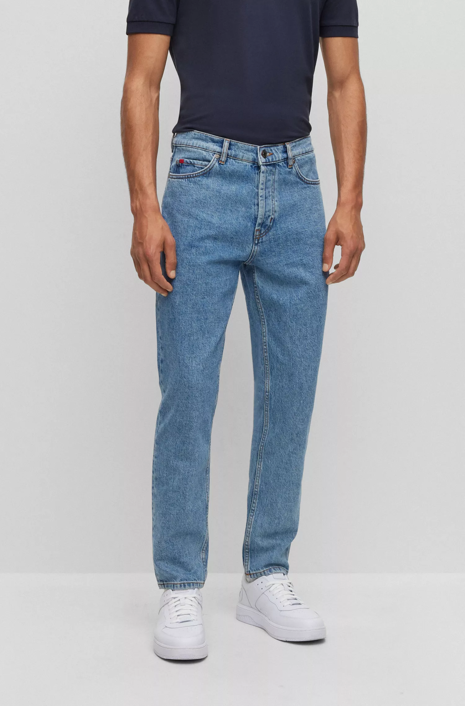 Calça jeans HUGO vermelha, corte afunilado, em denim azul com elasticidade confortável.
