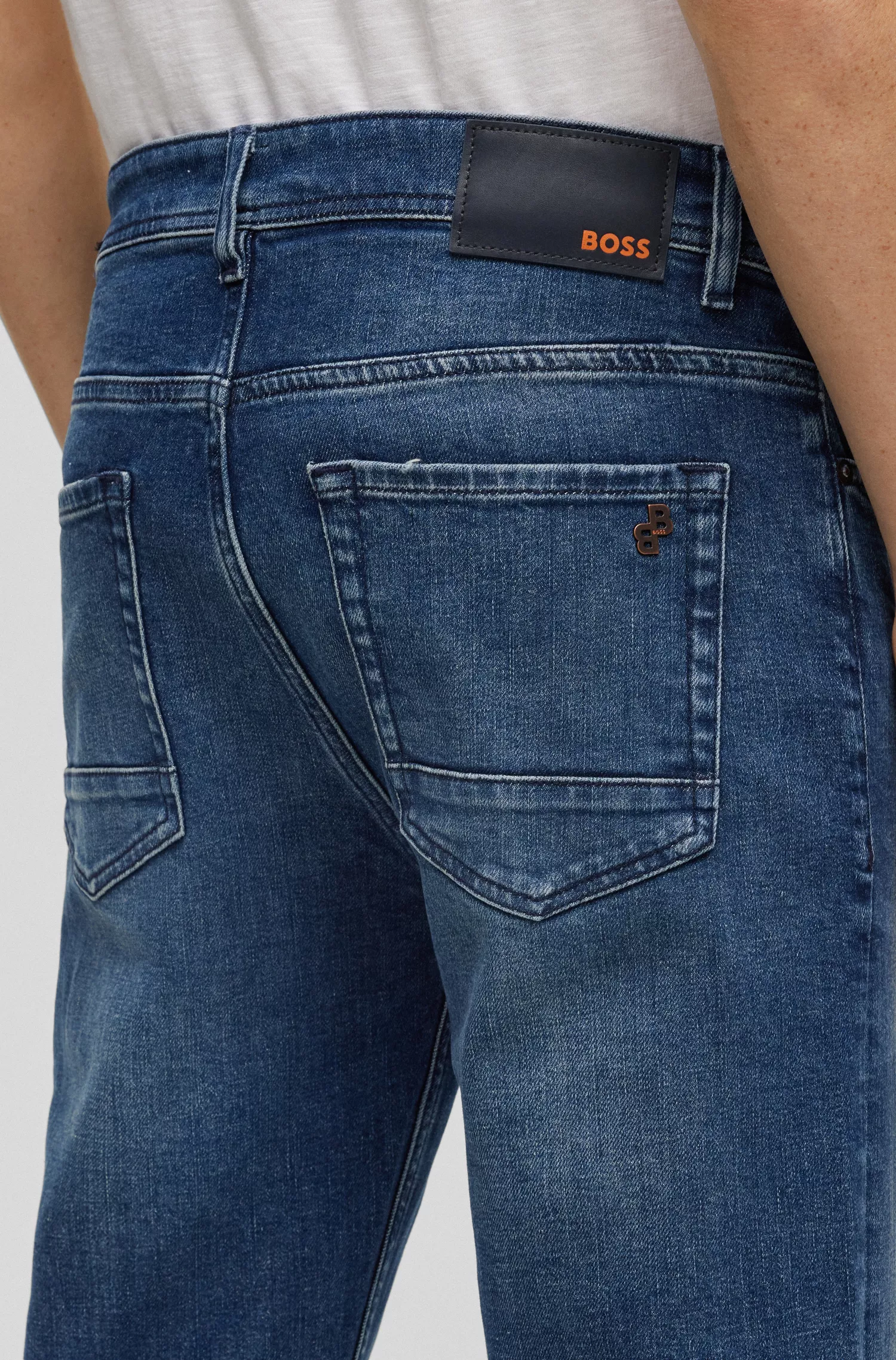 Calça jeans BOSS laranja, corte afunilado, em denim azul com elasticidade confortável.