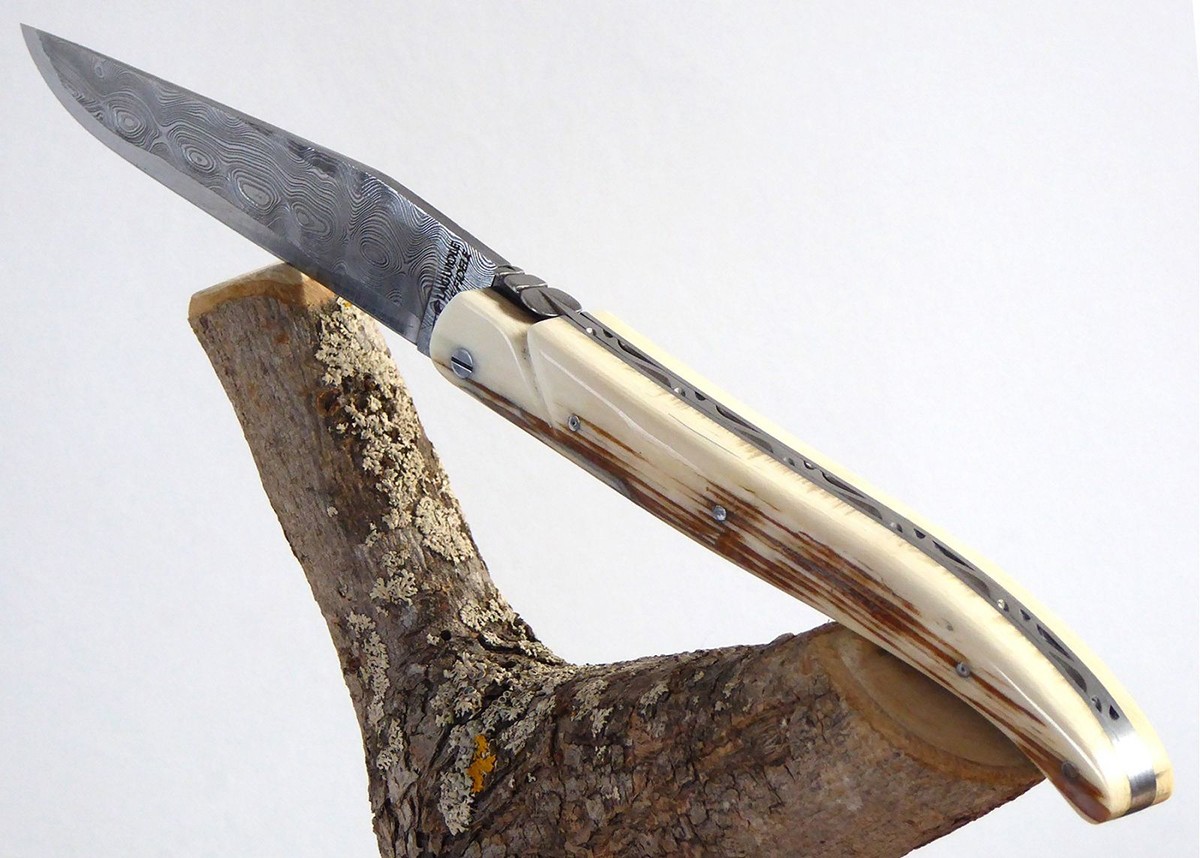 Couteau Laguiole avec une lame Damas et un manche en ivoire de Mammouth plein manche