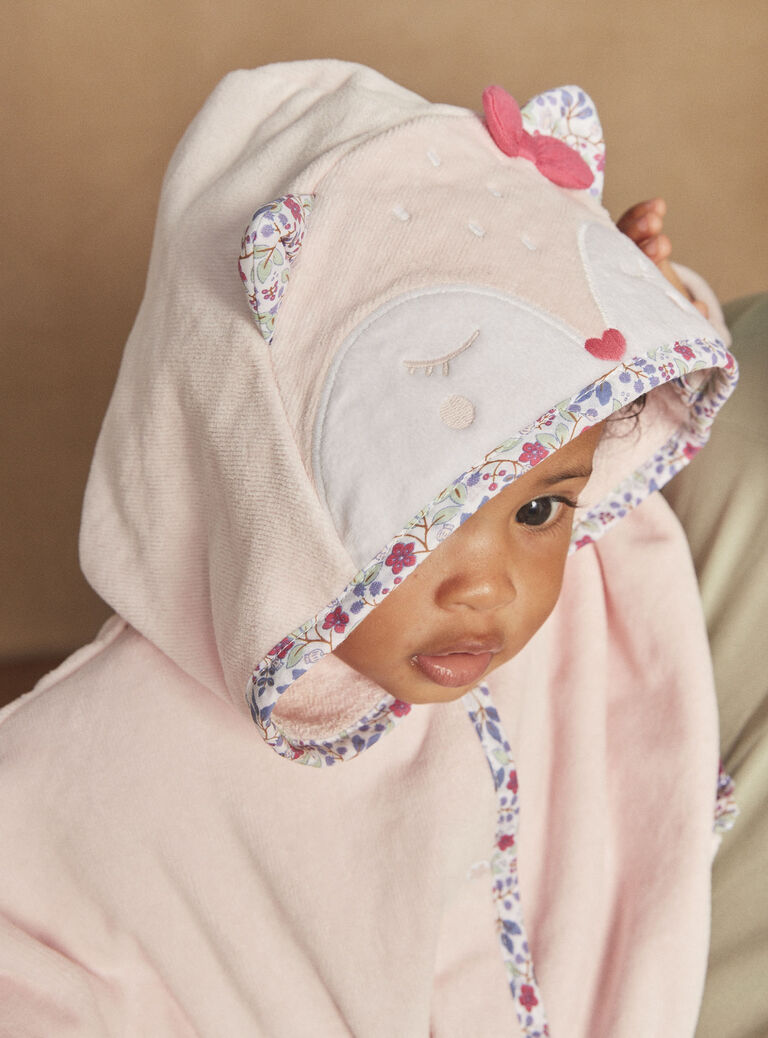 Cape de bain à capuche rose à motif fleuri.