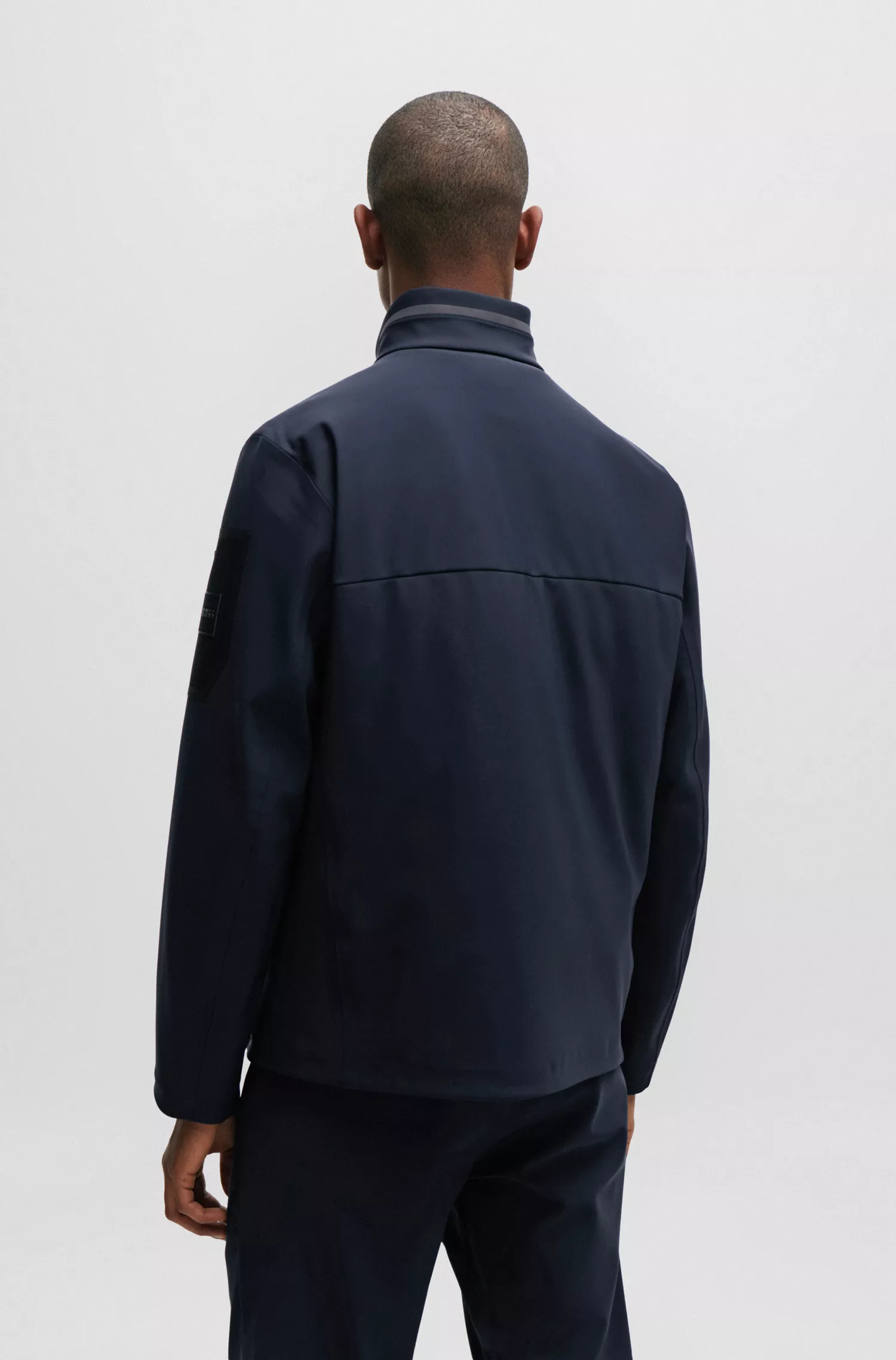 Jaqueta softshell verde-repelente à água da BOSS com bolso na manga com a marca.