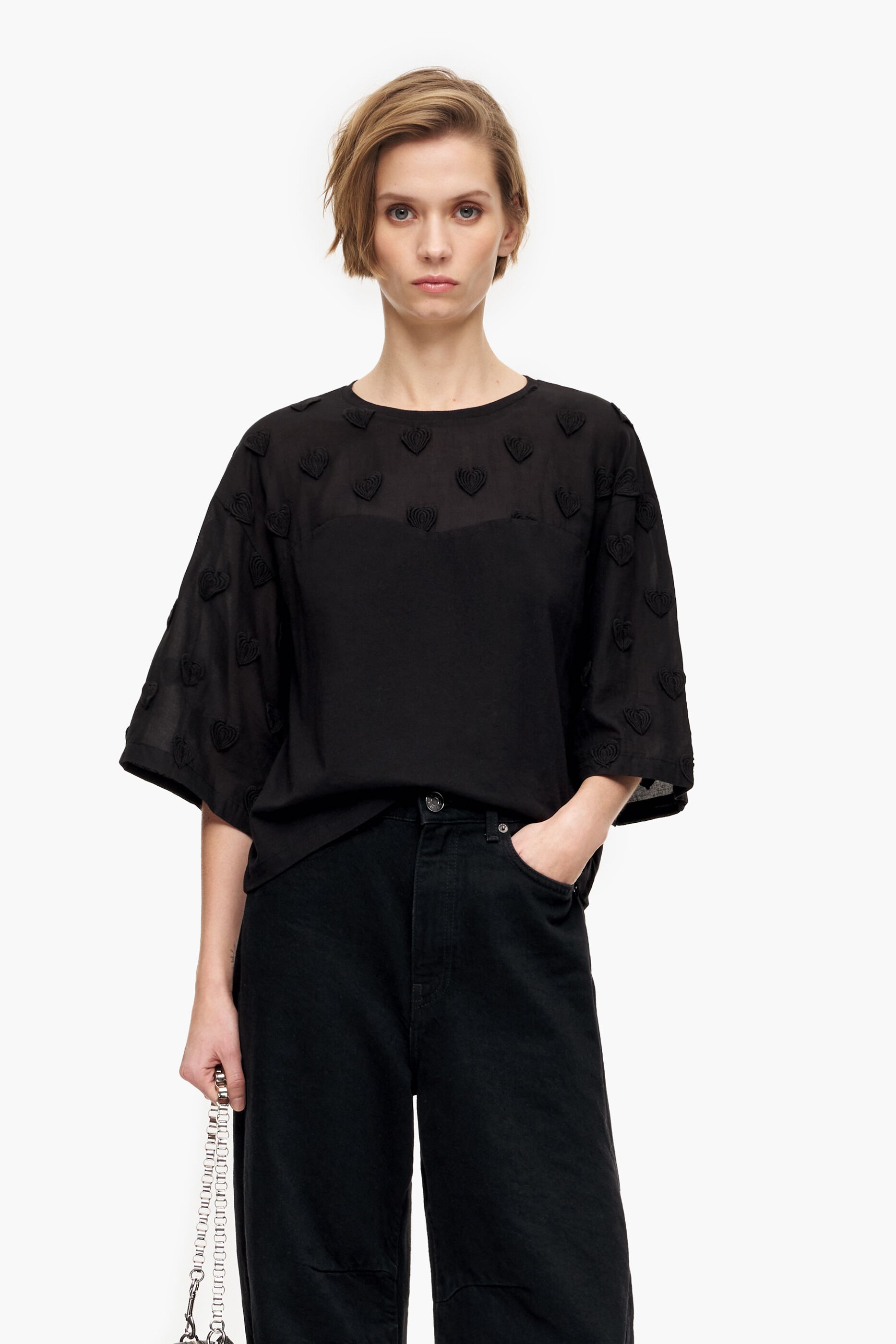 Camiseta preta de algodão com corações.