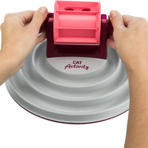 Alimentador interativo Trixie com roda, rosa e branco, para gatos.