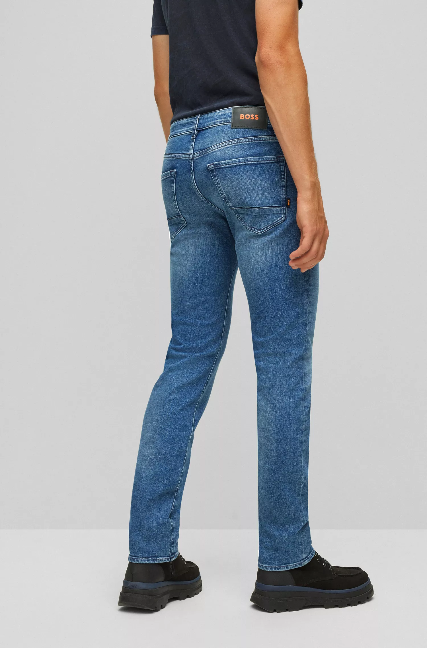 Calça jeans BOSS laranja, corte regular, em denim azul com elasticidade confortável.