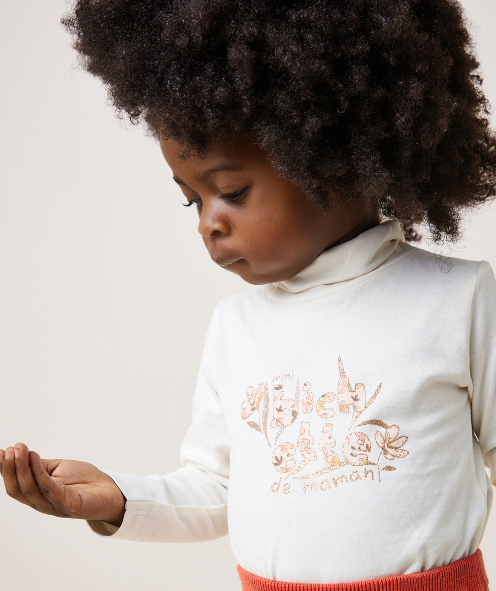 SOUS-PULL BÉBÉ FILLE COL ROULÉ EN COTON BIO ÉCRU ET MESSAGE PAILLETÉ