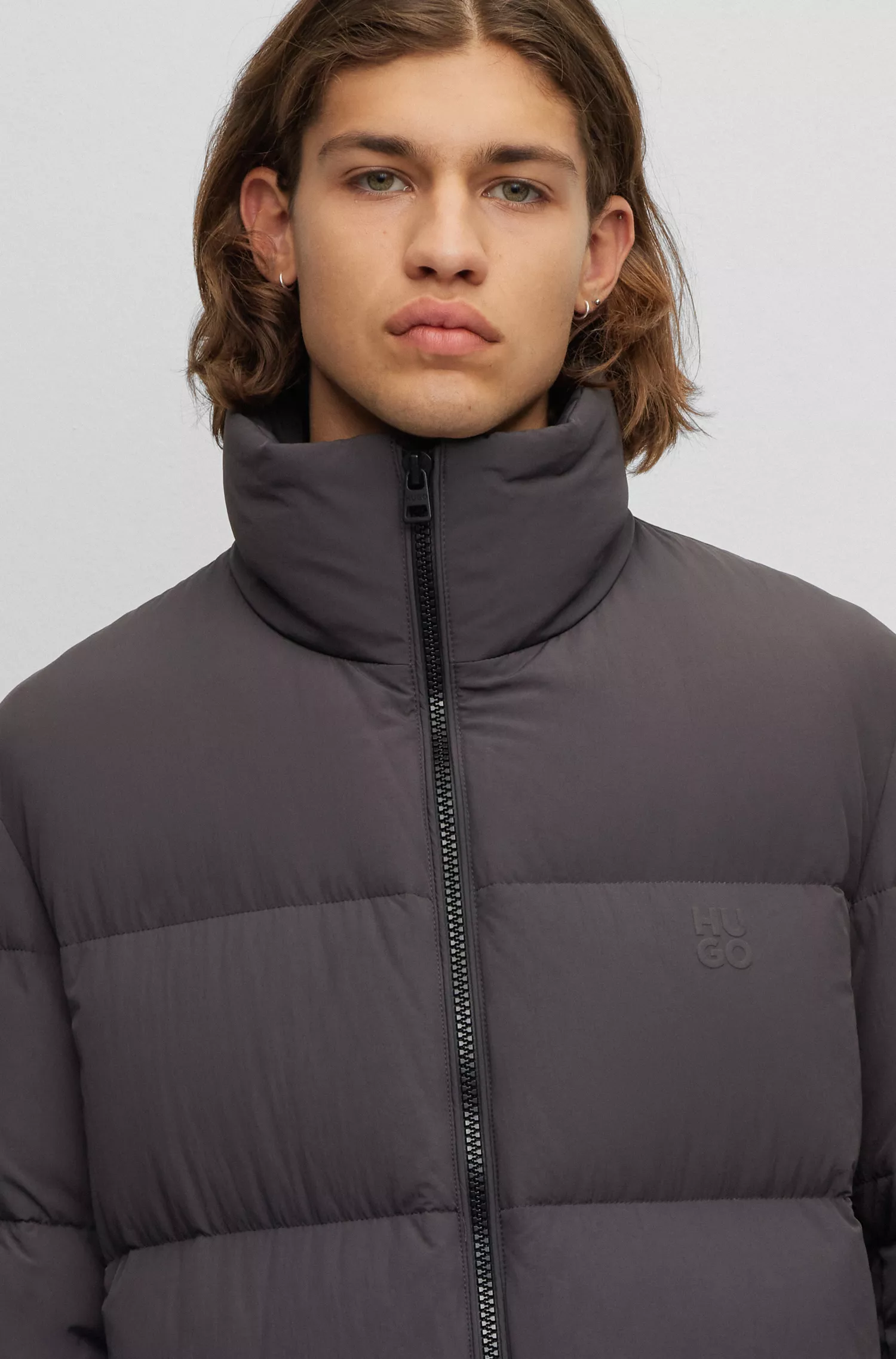 Casaco puffer HUGO vermelho, impermeável, com logotipos sobrepostos.