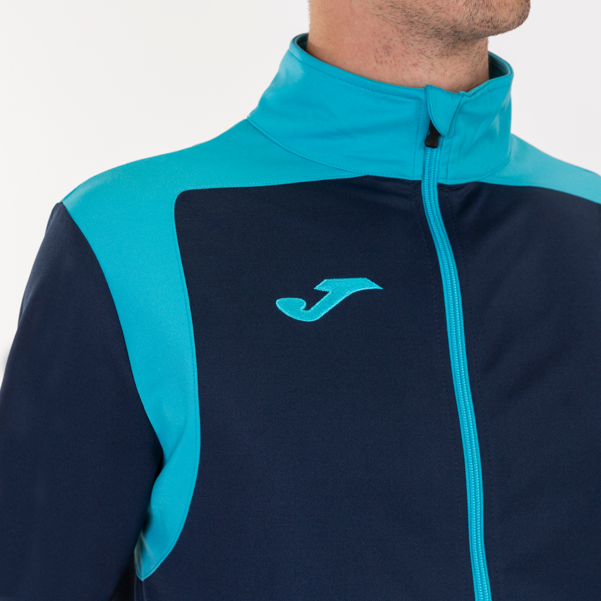 Conjunto de treino Joma Championship V nas cores azul marinho, turquesa e fluorescente.