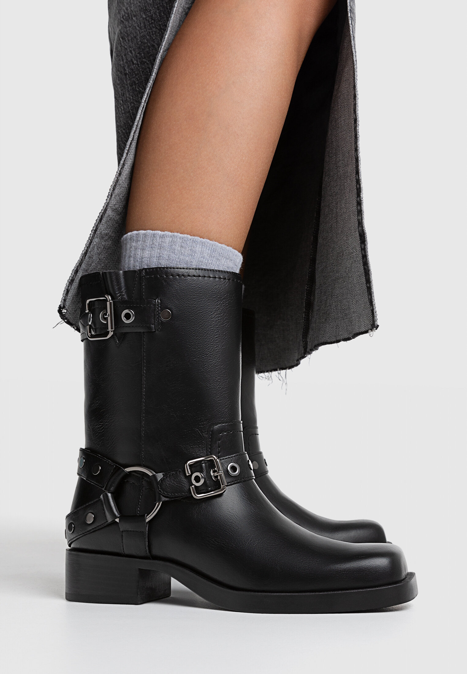 Botas de cano curto estilo motociclista, sem salto, com detalhes de fivela.